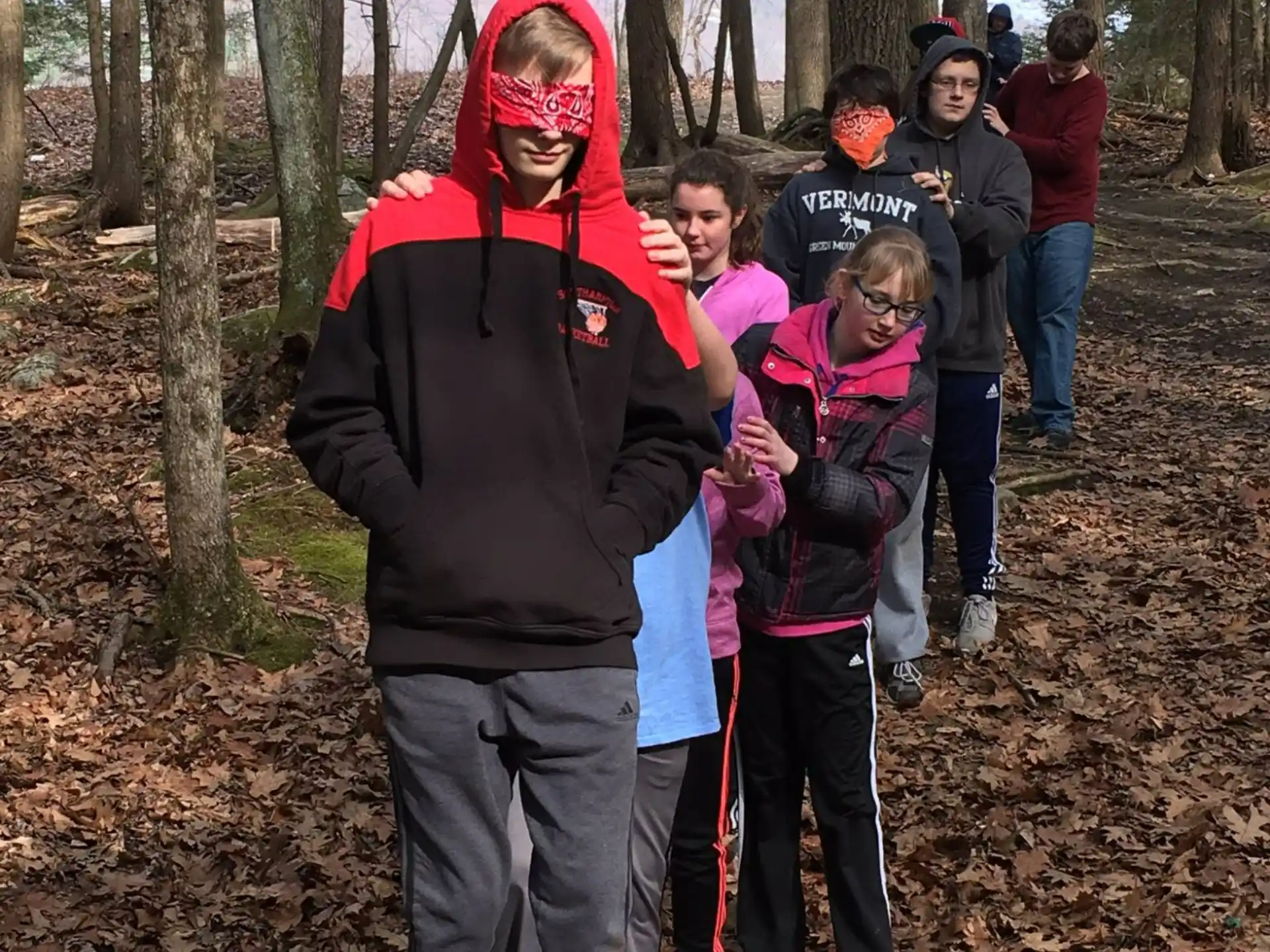 a group of people standing in a forest