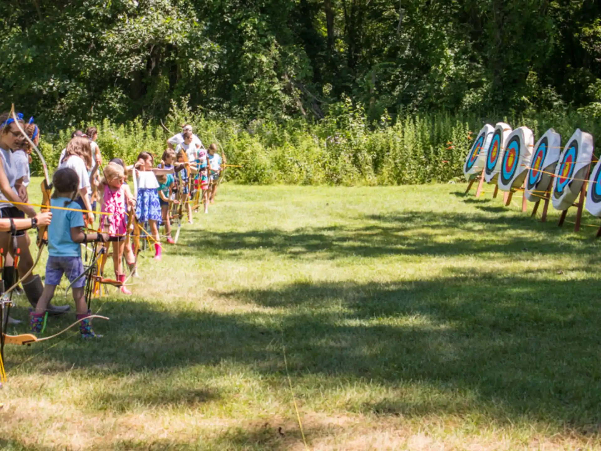 a group of people in a field with large white and blue tents