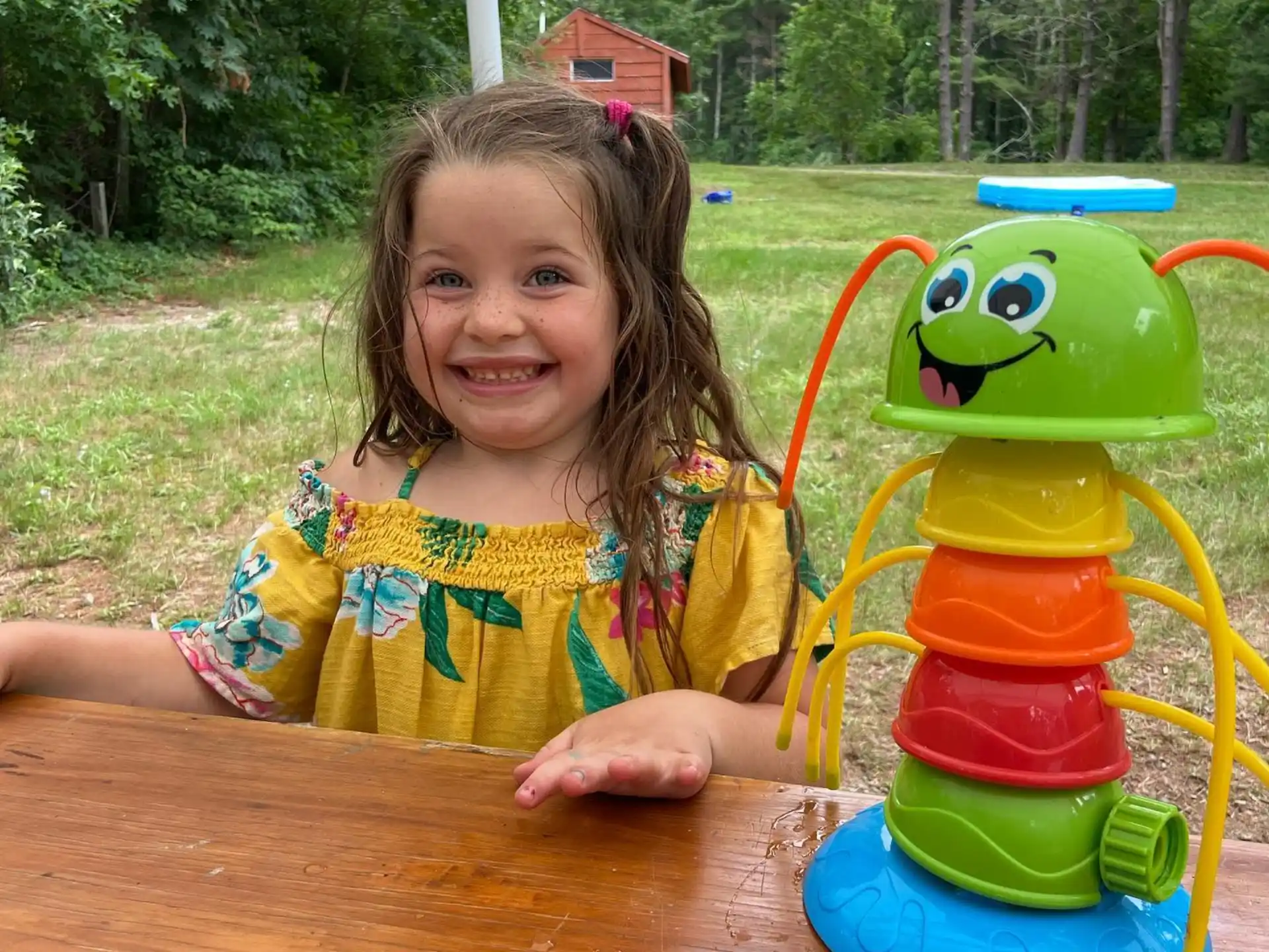 a girl sitting next to a toy