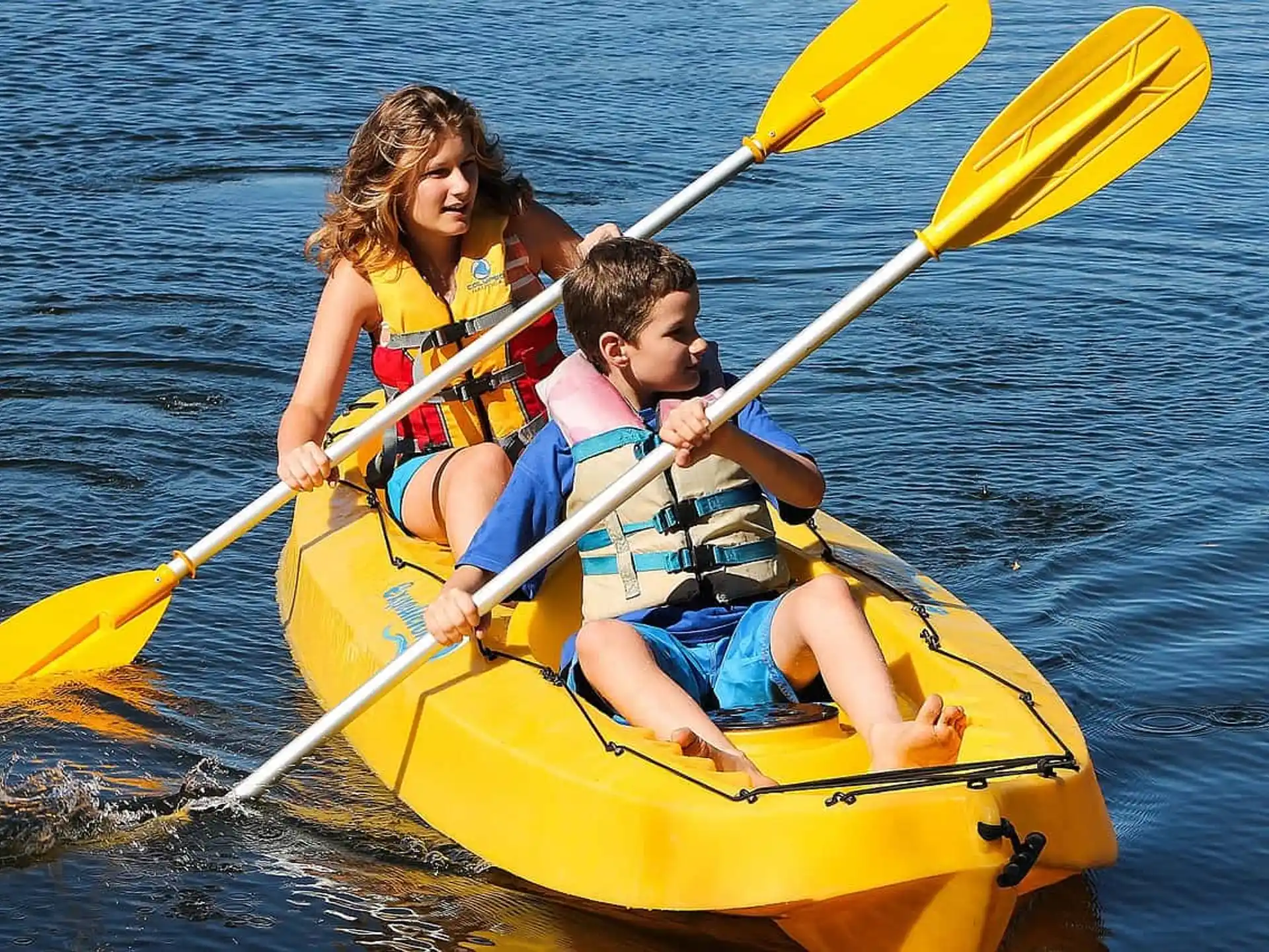 a group of people in a yellow kayak on water