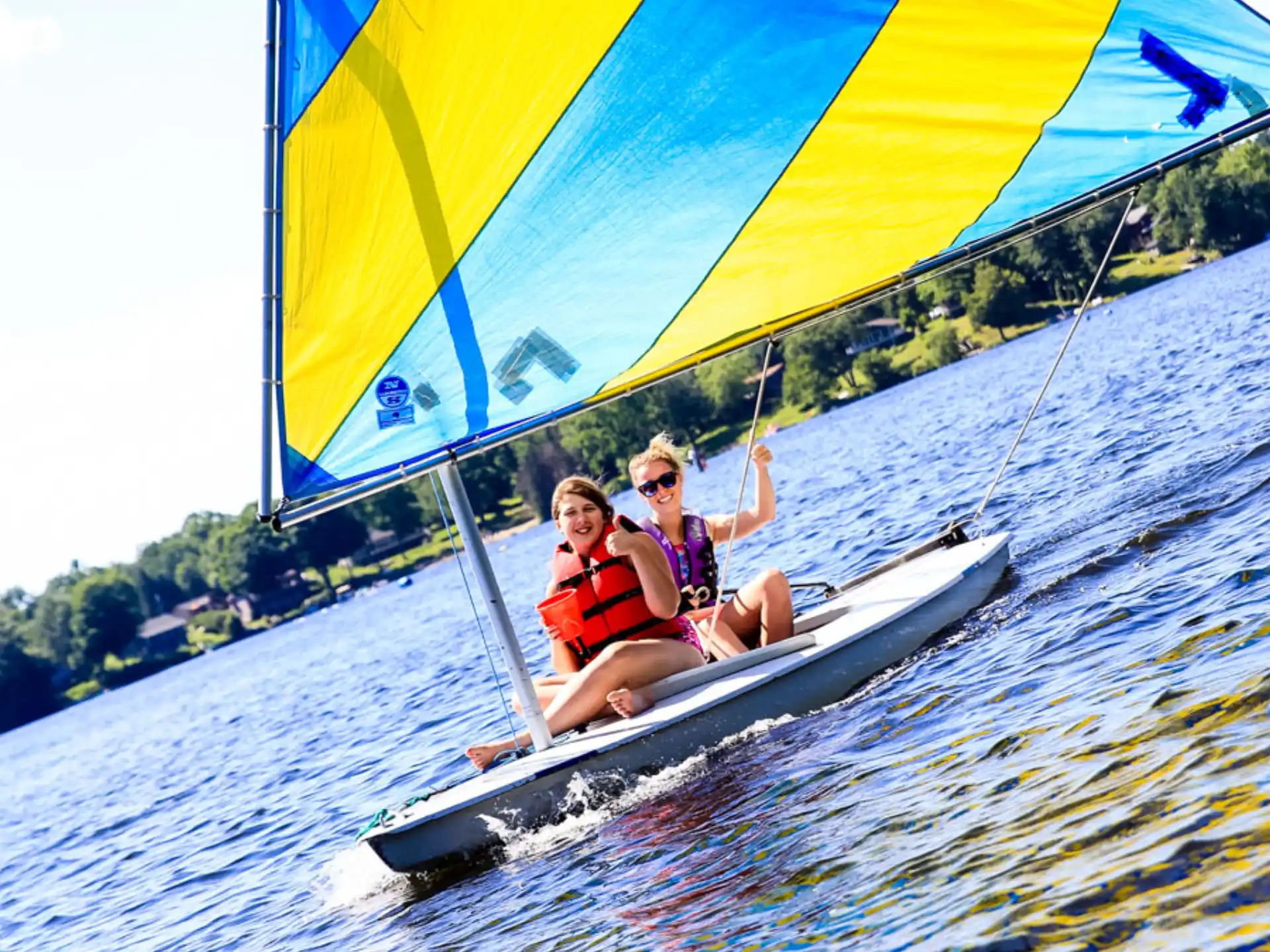 a couple of people on a sailboat on water