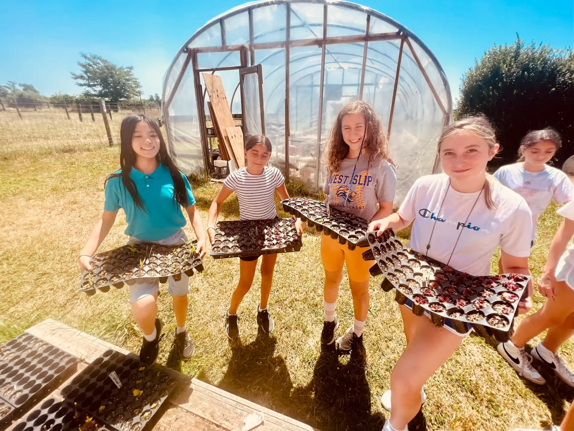 a group of girls posing for a picture in front of a large metal ball