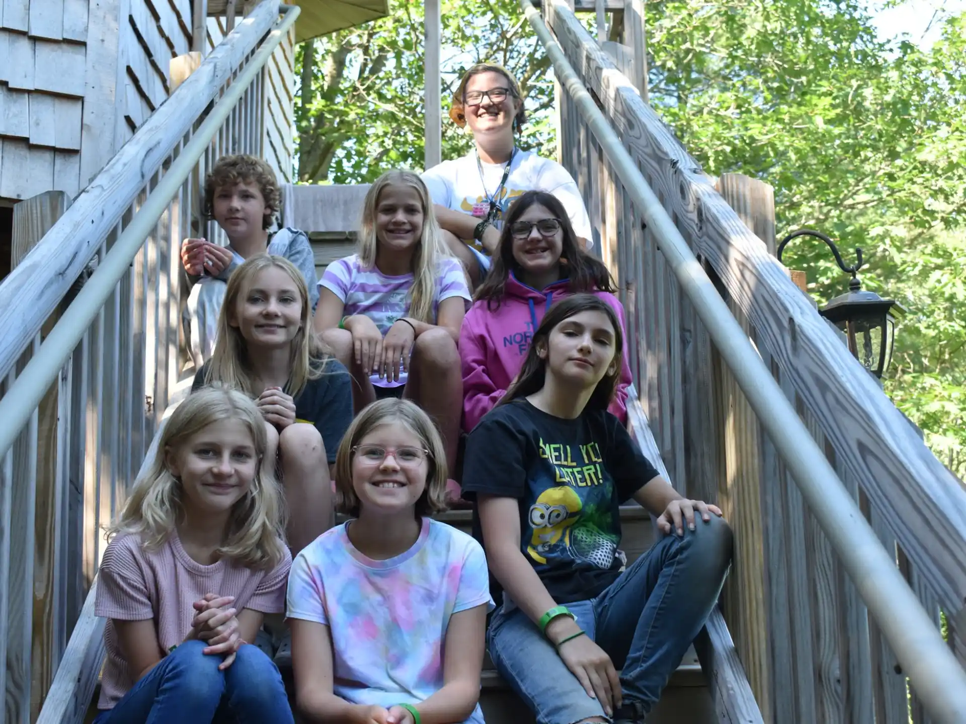 a group of people posing for a photo on a wooden bridge