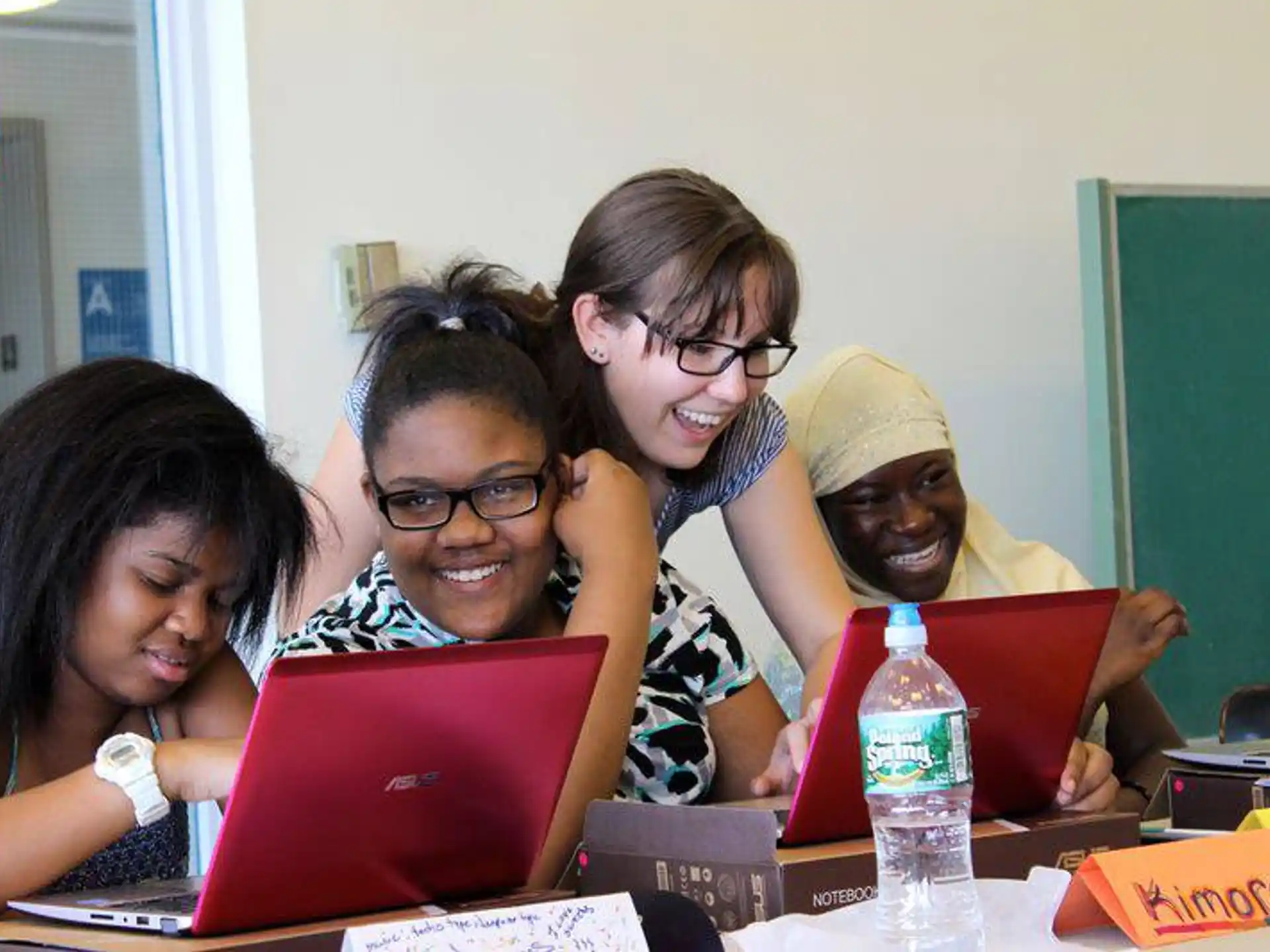 a group of people looking at a laptop