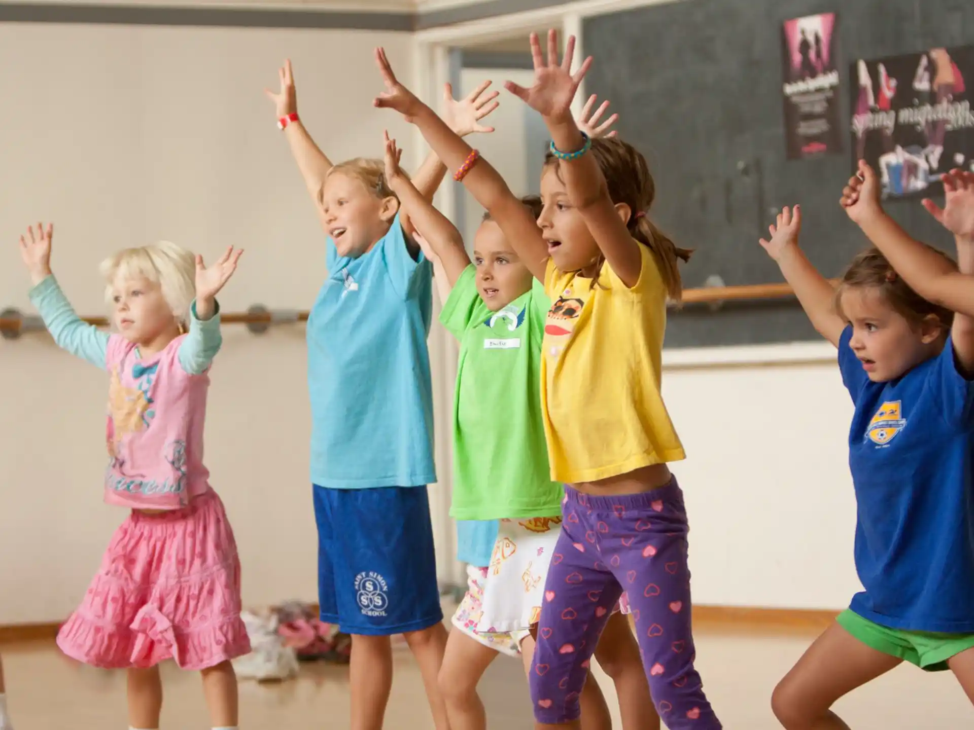 a group of children raising their hands