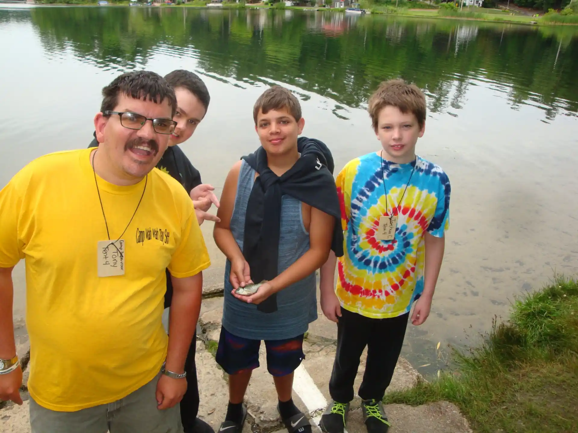 a group of people posing for the camera next to a body of water