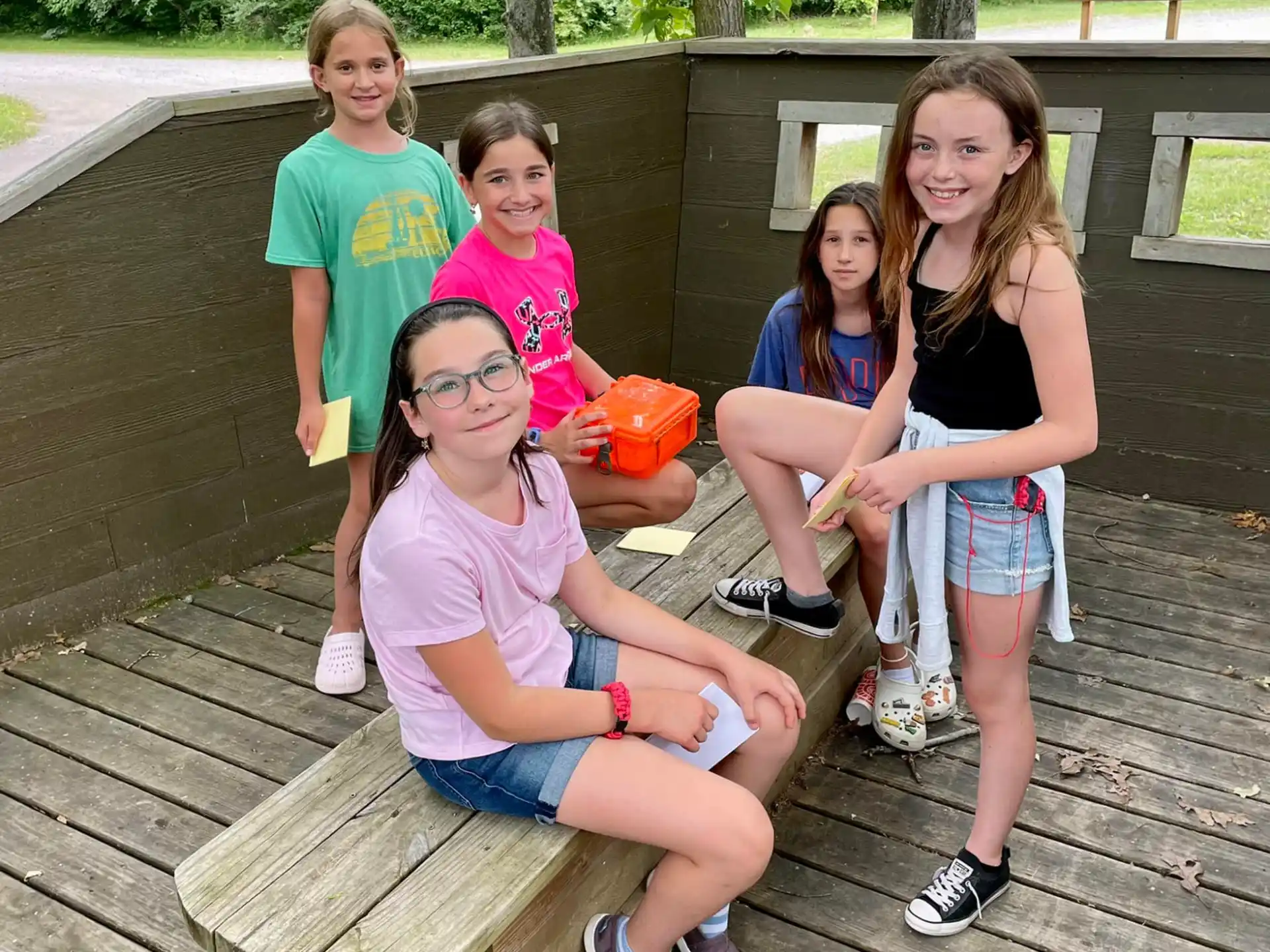 a group of kids posing for a photo on a wooden deck