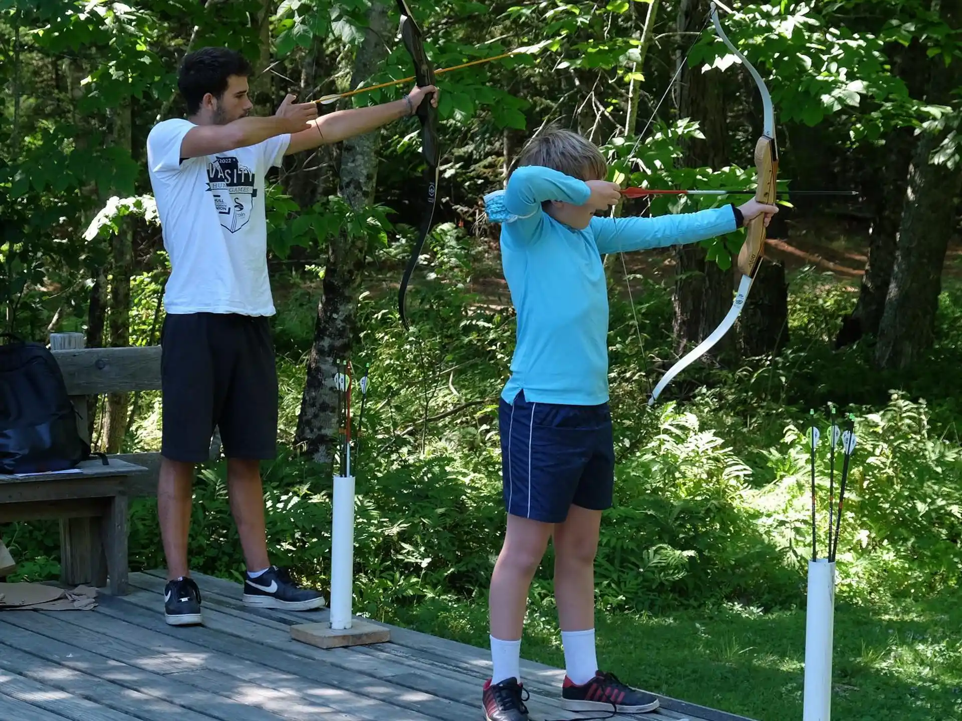 a man and a woman holding bows and arrows