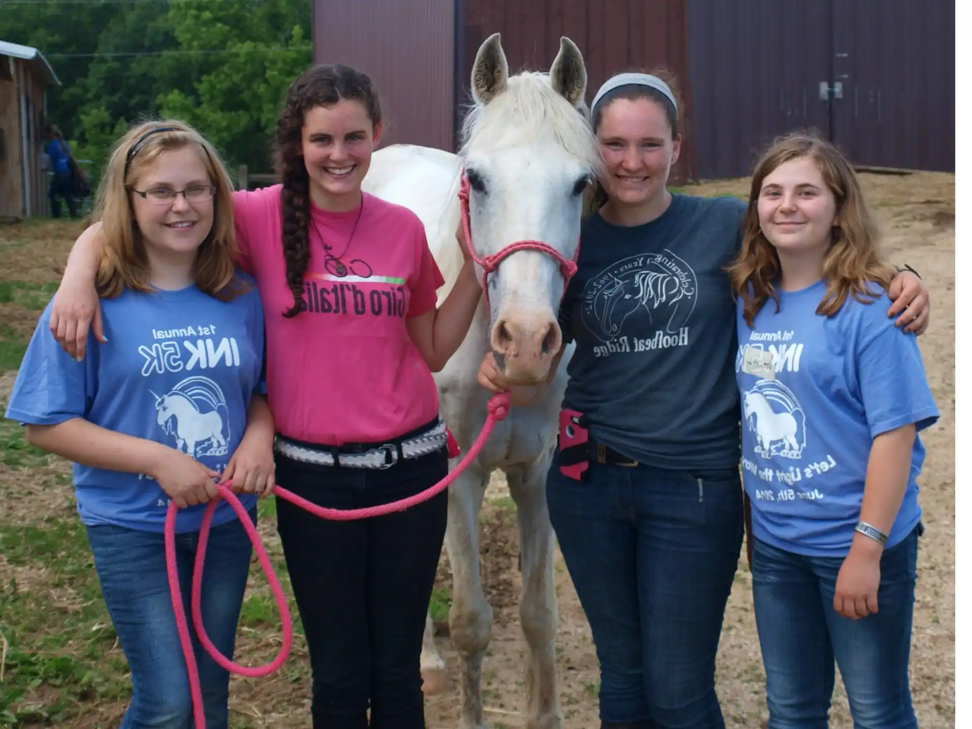 a group of people posing with a horse
