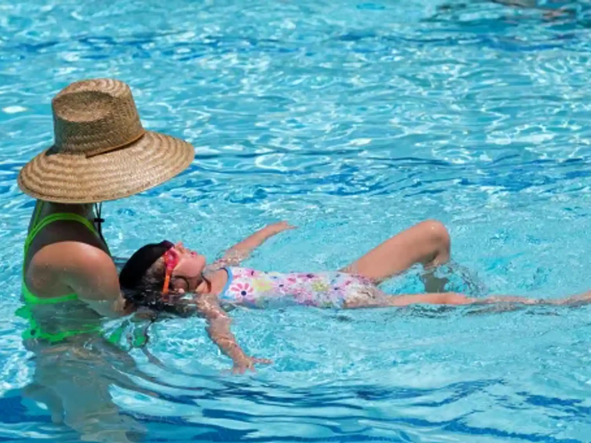 a person and a baby swimming in a pool