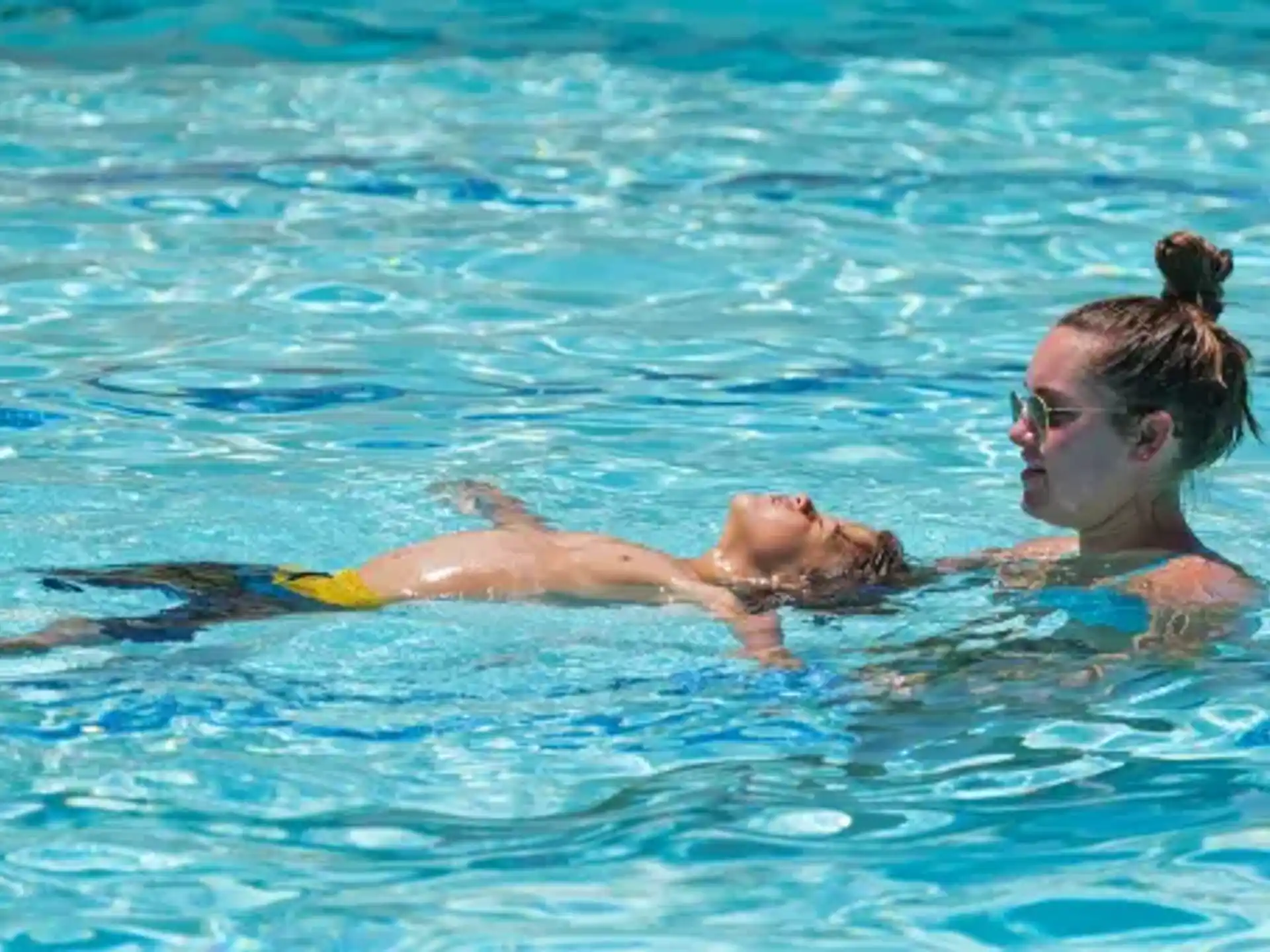 a person and a child swimming in a pool