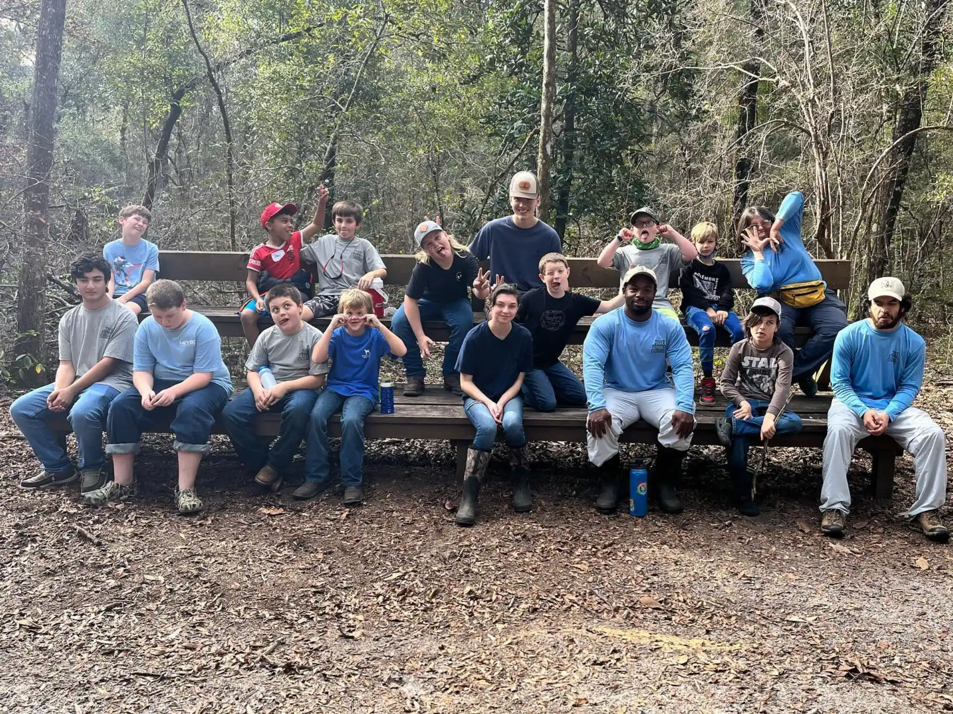 a group of people sitting on a bench in the woods