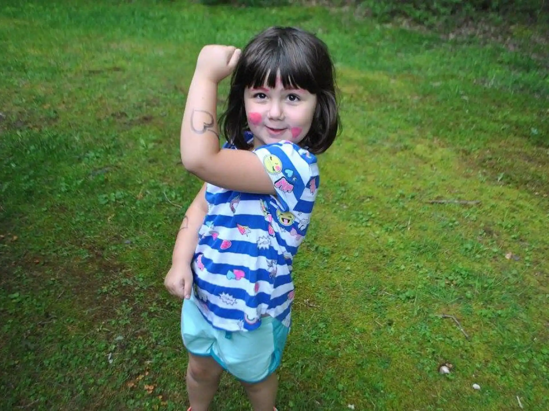 a girl standing in a grassy area