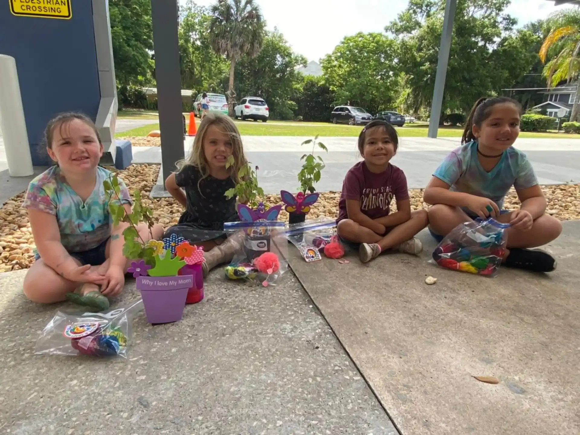 a group of children sitting on the ground with flowers