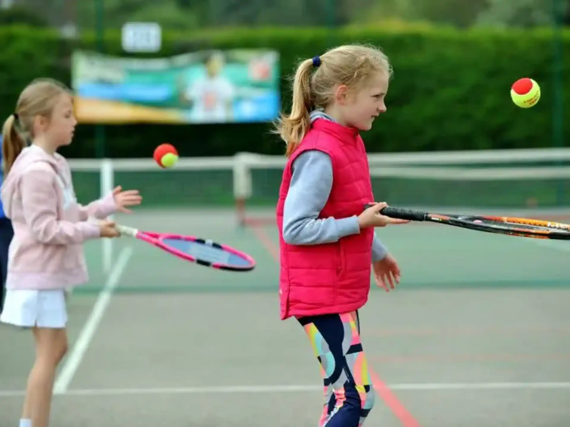 girls playing tennis on a court