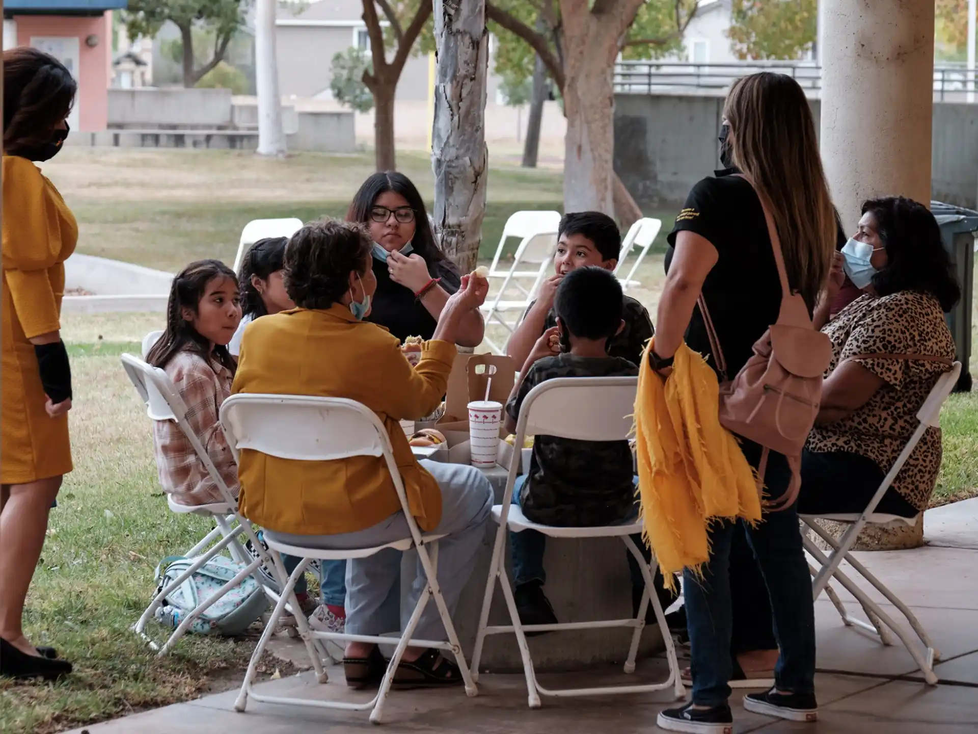 a group of people sitting at a table outside