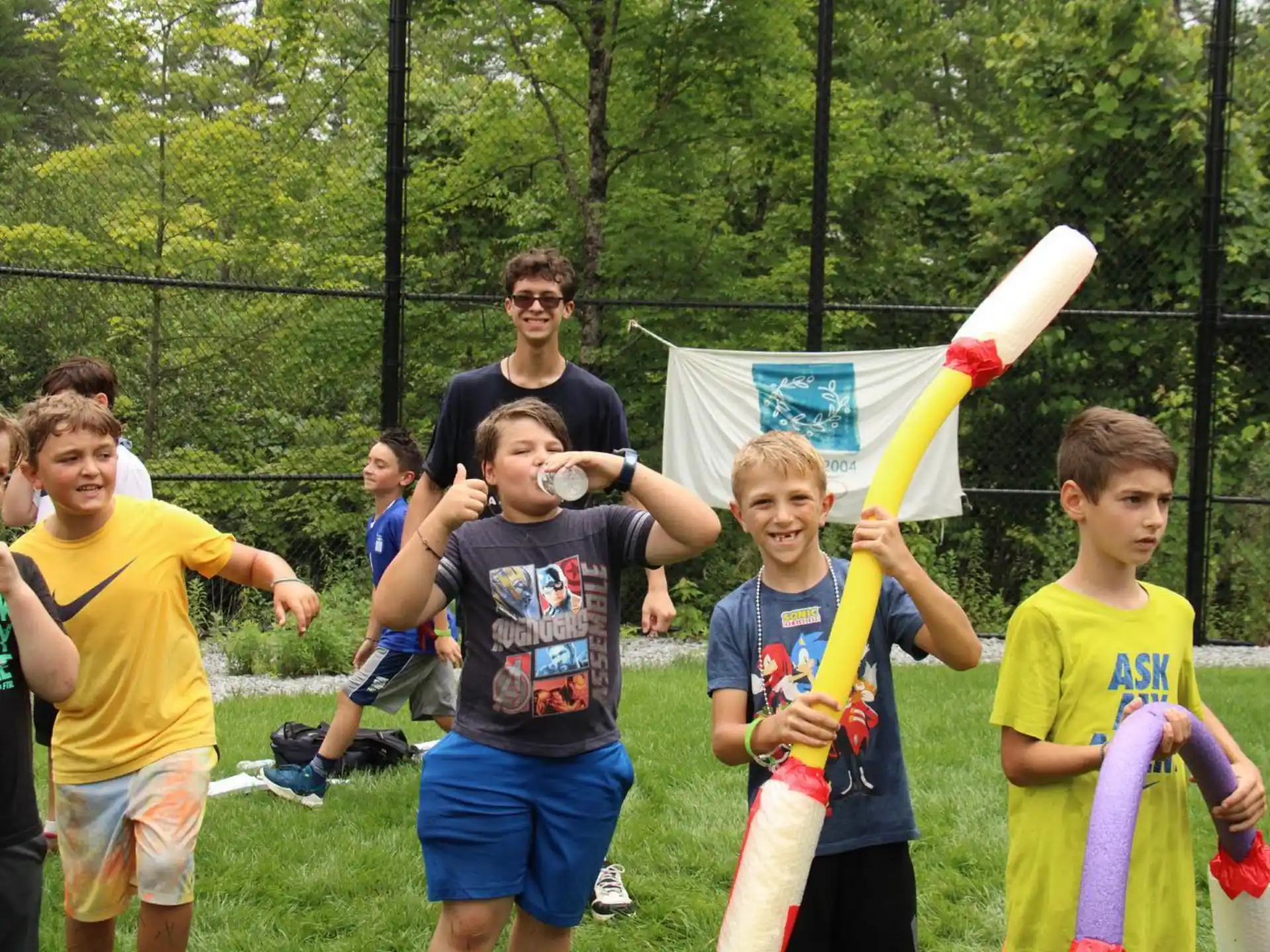 a group of kids holding a yellow and blue stick