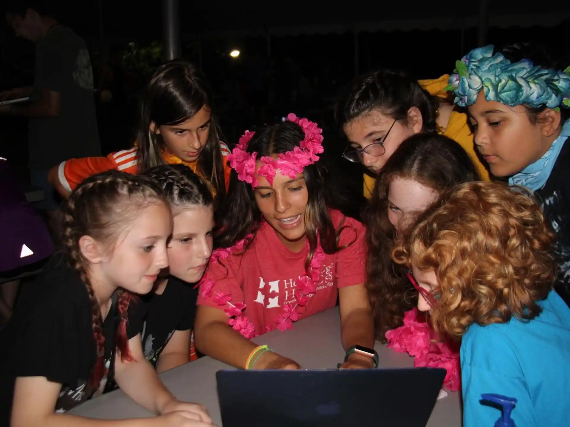 a group of people looking at a laptop