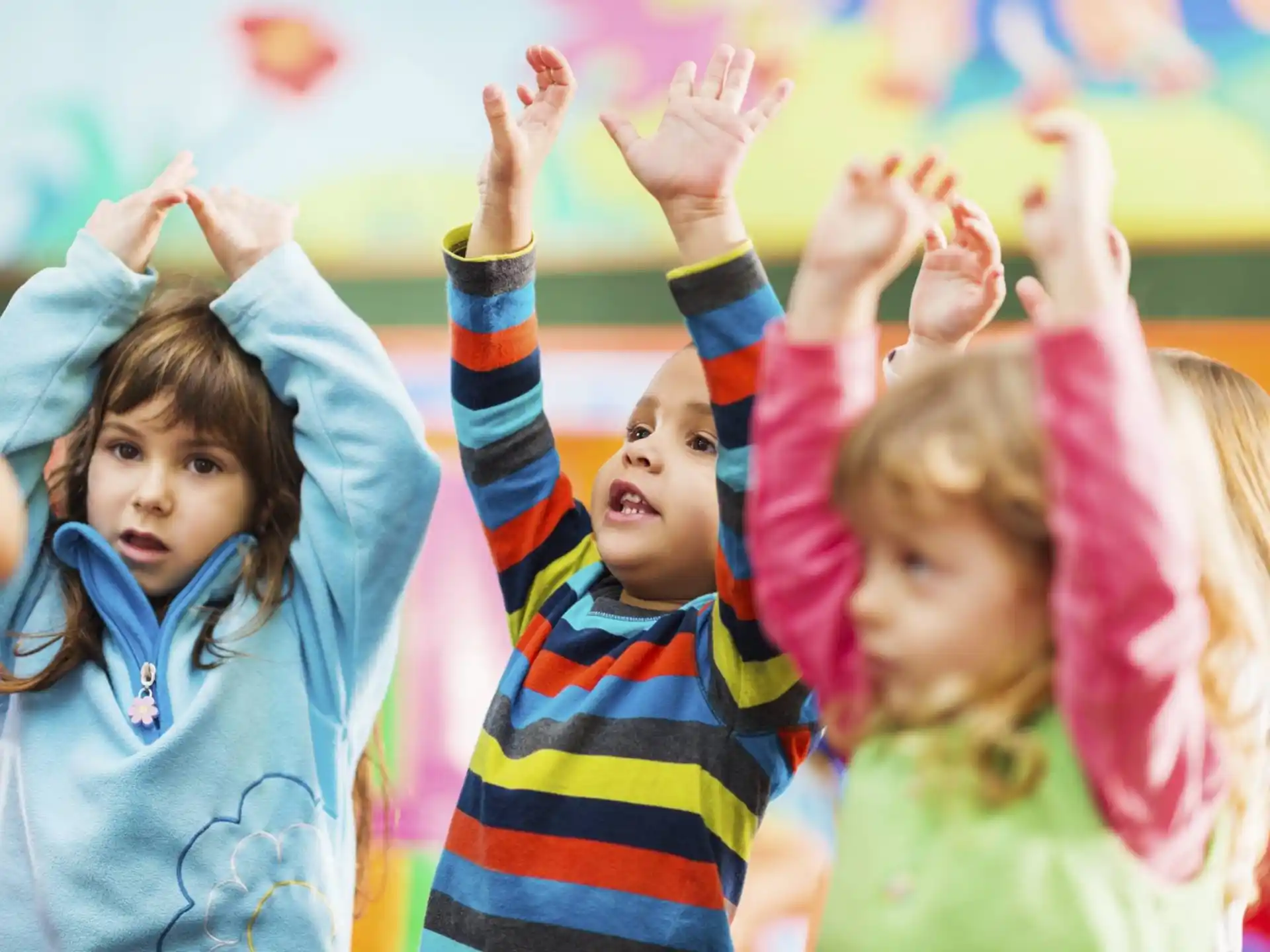 a group of children raising their hands