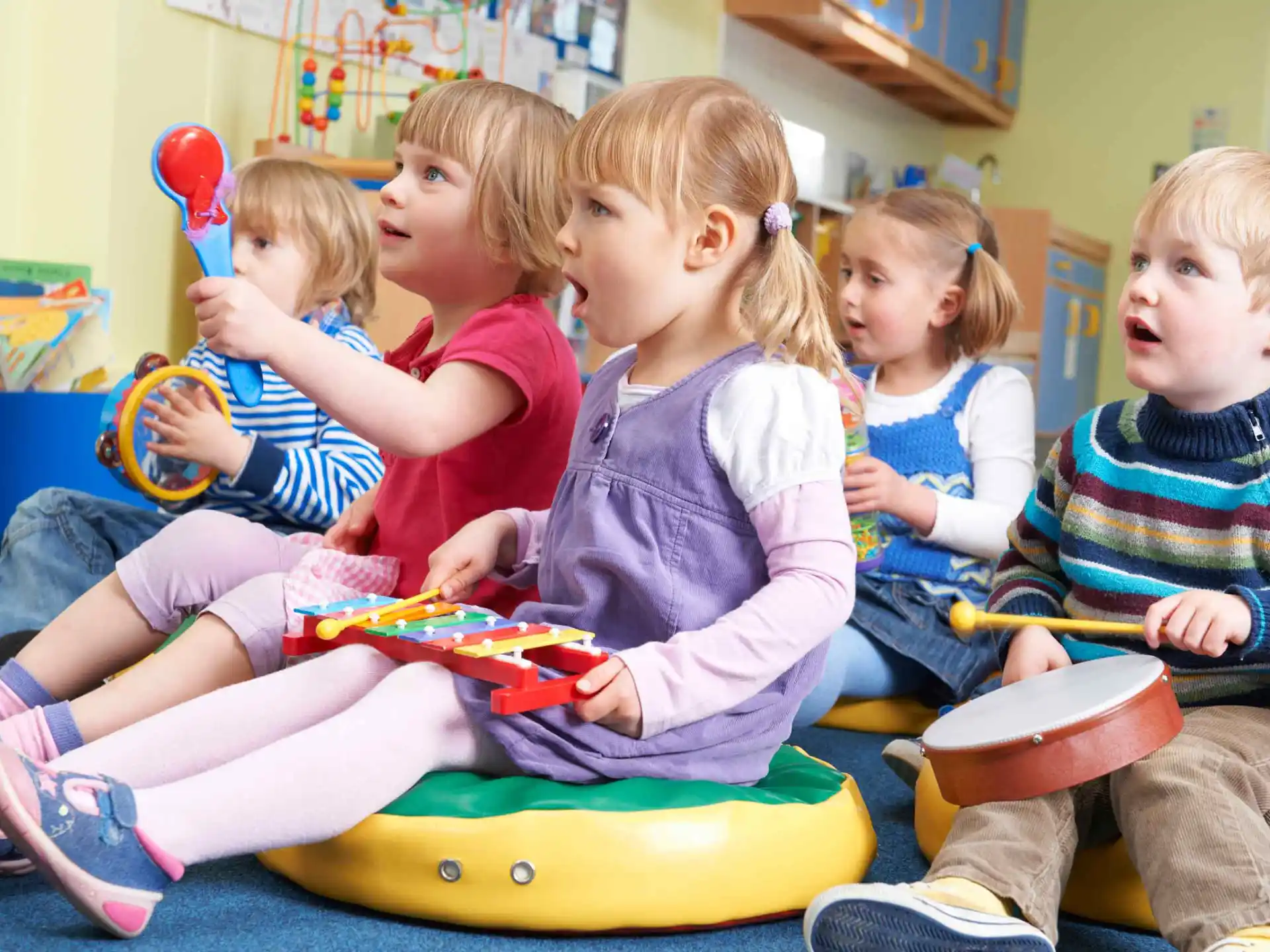 a group of children sitting on a yellow toy in a room