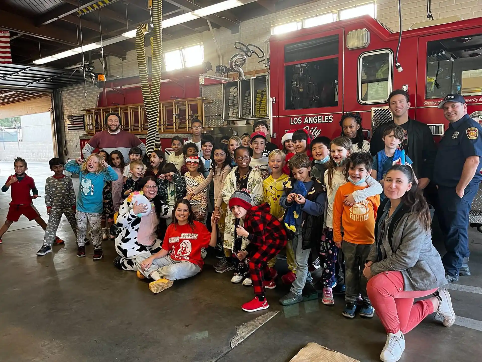 a group of people posing for a photo in front of a firetruck