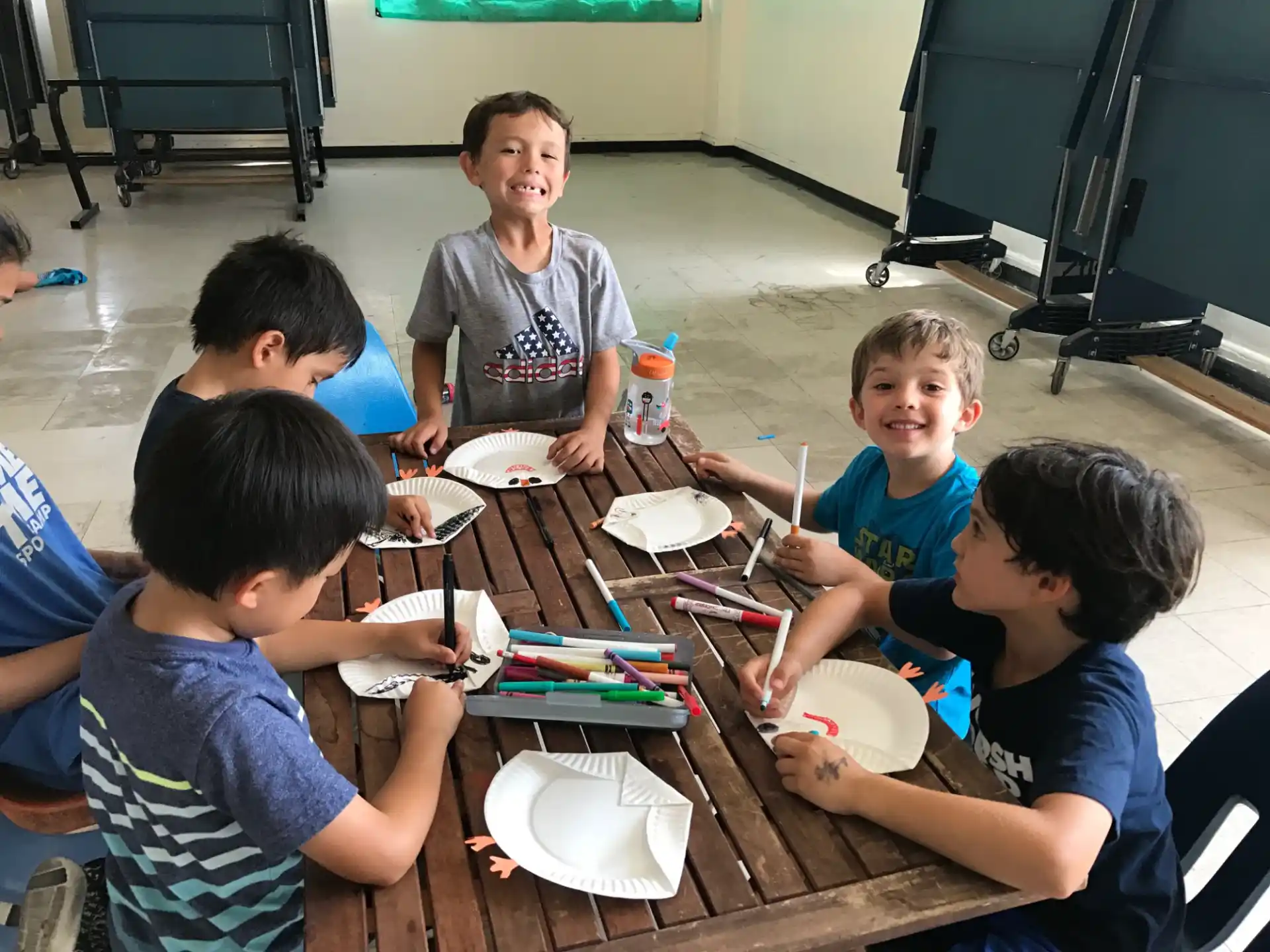 a group of children sitting around a table eating food