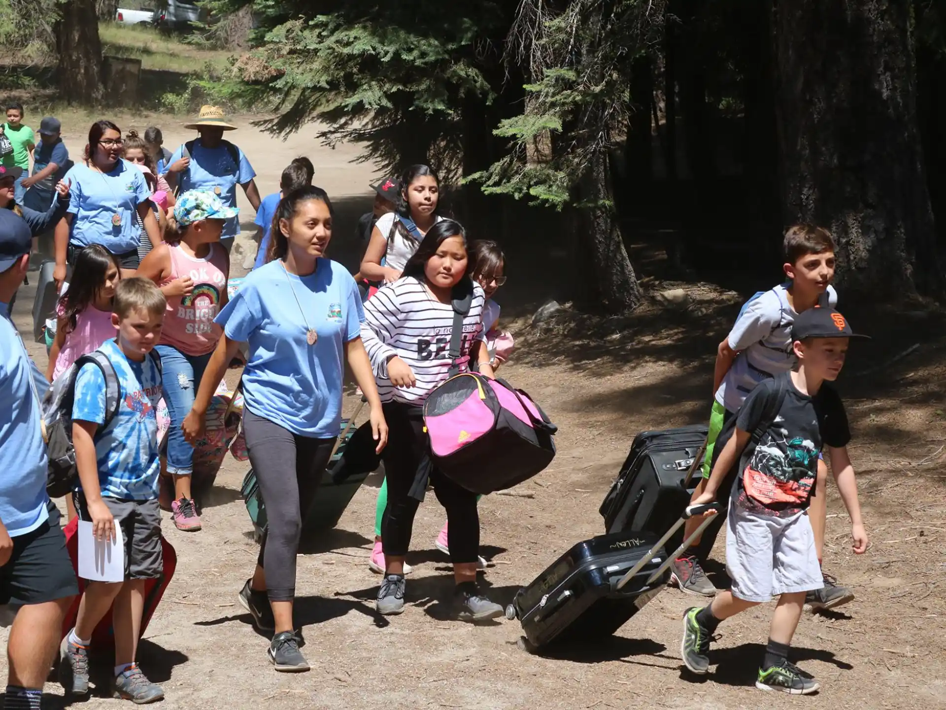 a group of people walking on a dirt path