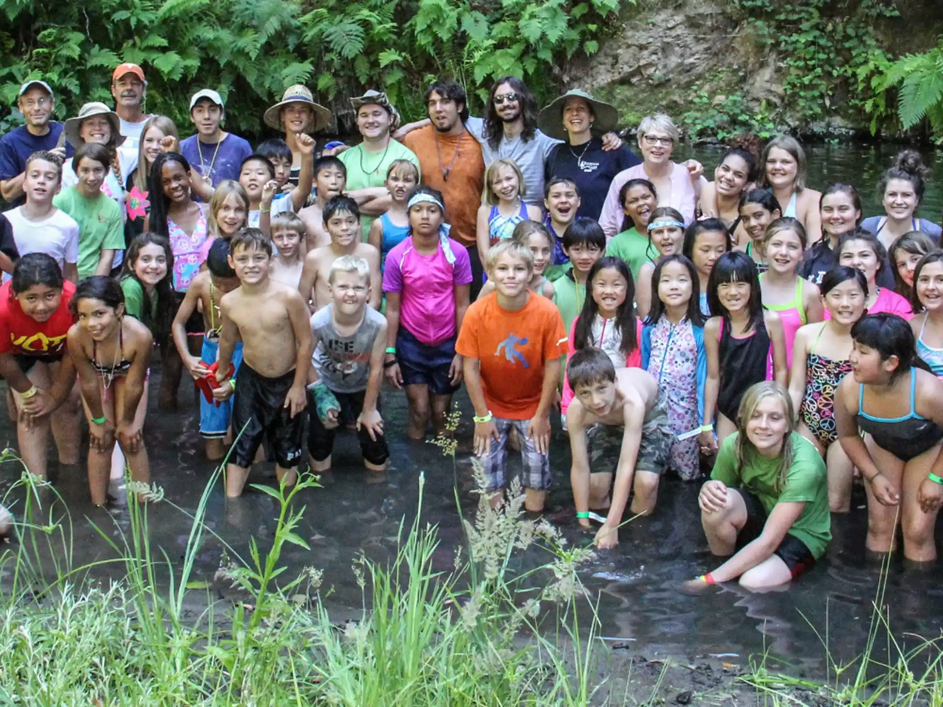 a group of people posing for a photo in a river