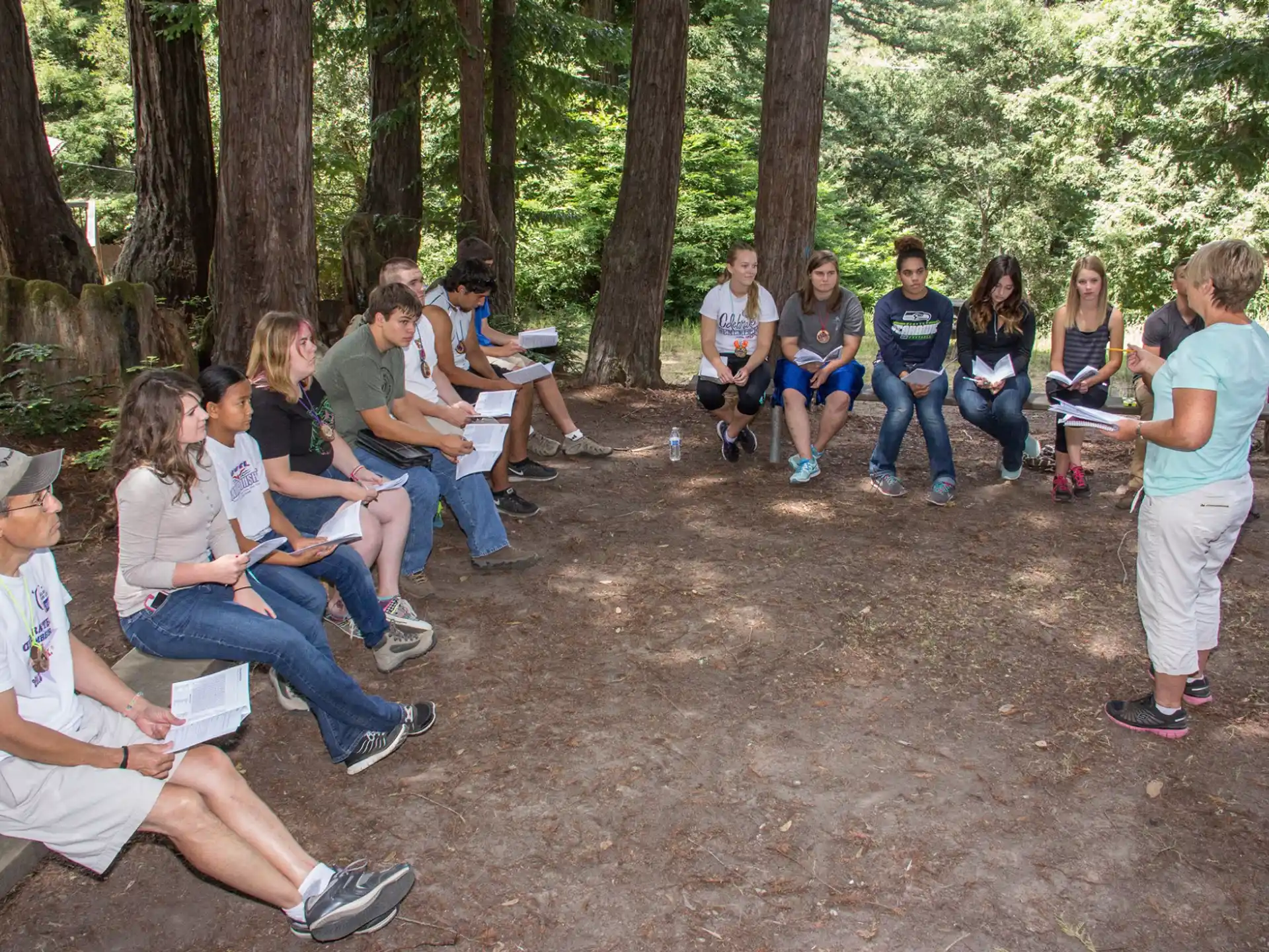 a group of people sitting in a forest