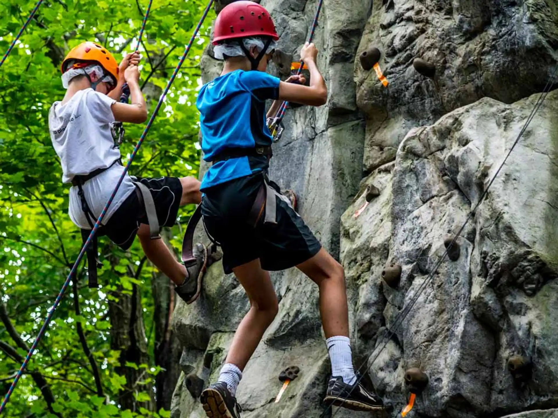 a couple of people climbing a rock
