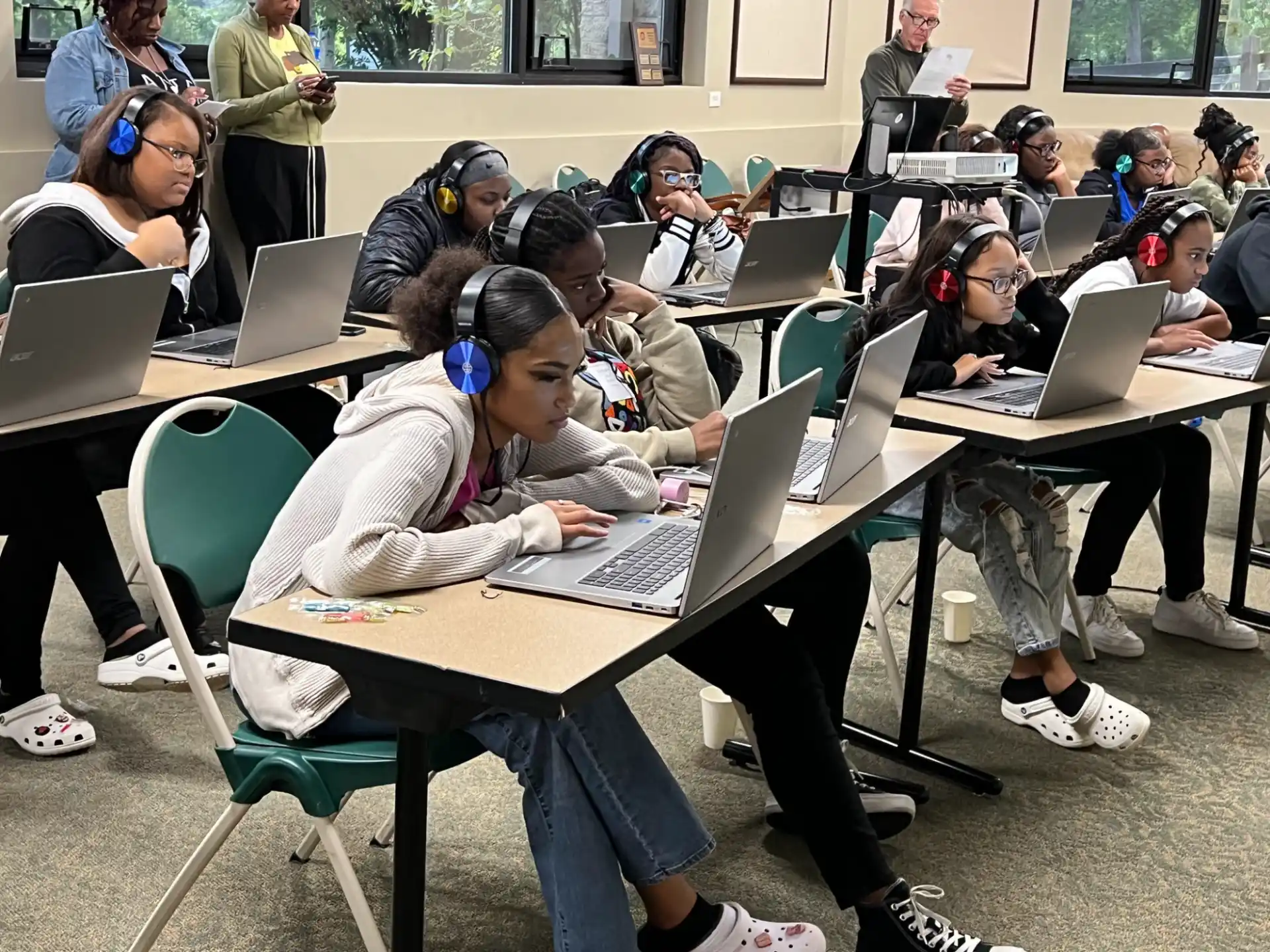 a group of people sitting at tables with laptops