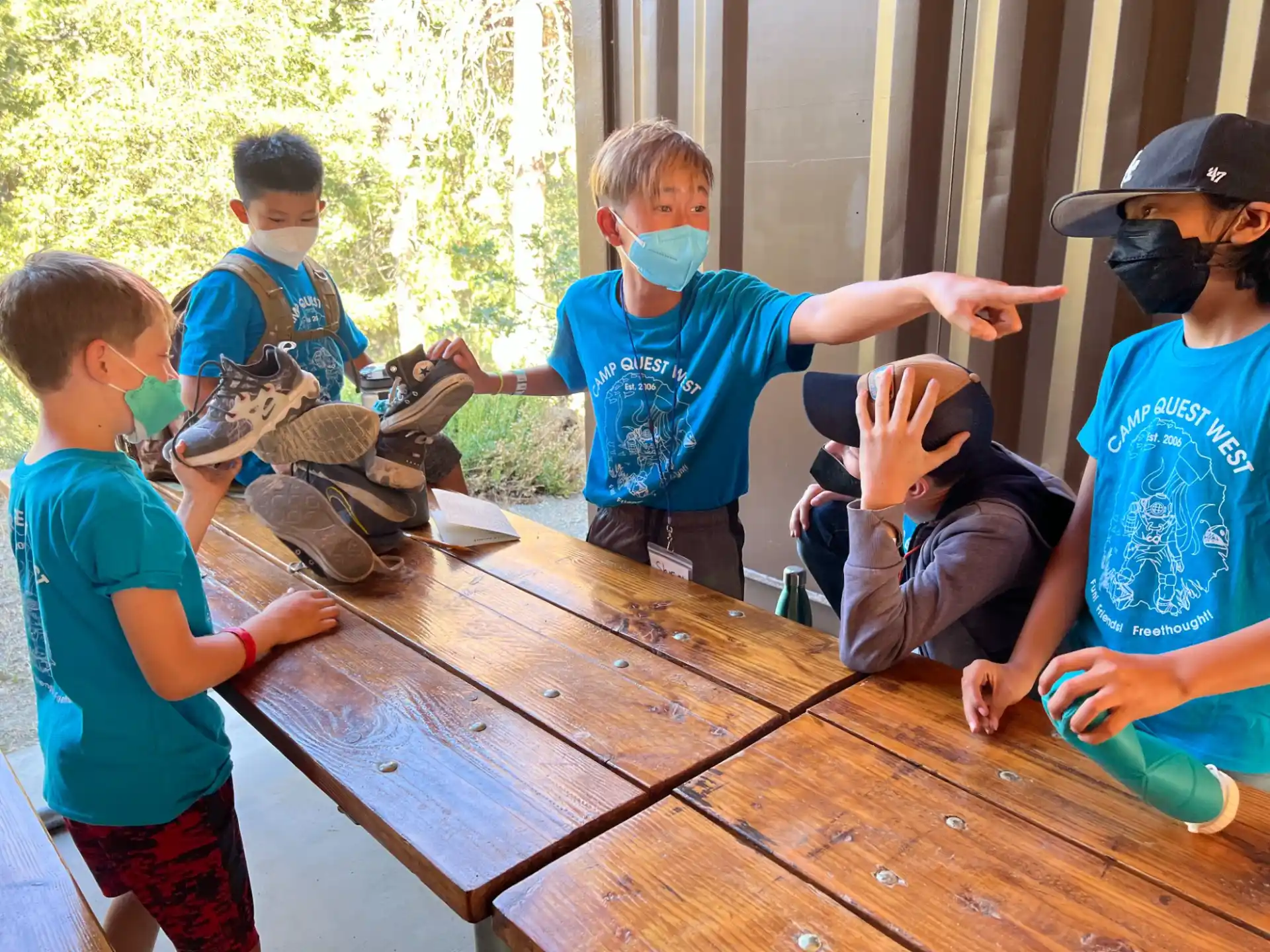 a group of kids playing with a turtle on a wooden table