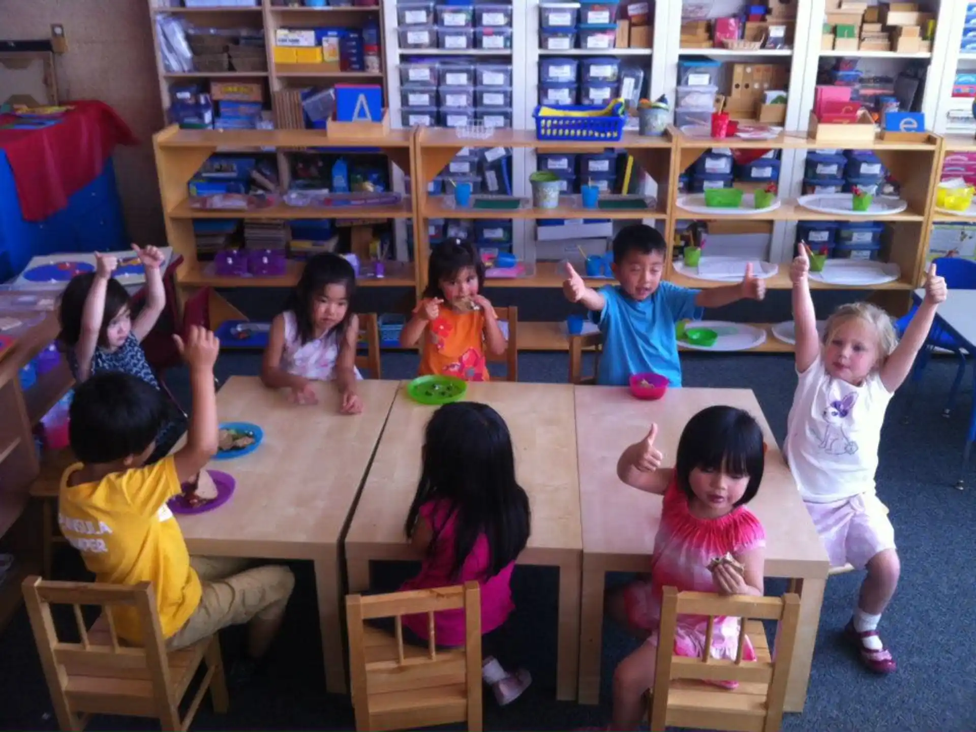 a group of children sitting around a table