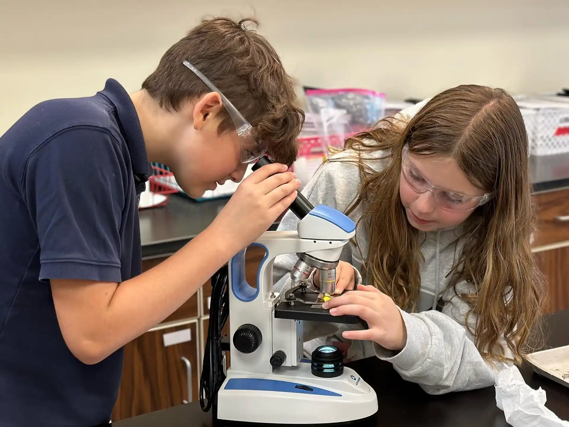 a man and a woman looking at a microscope
