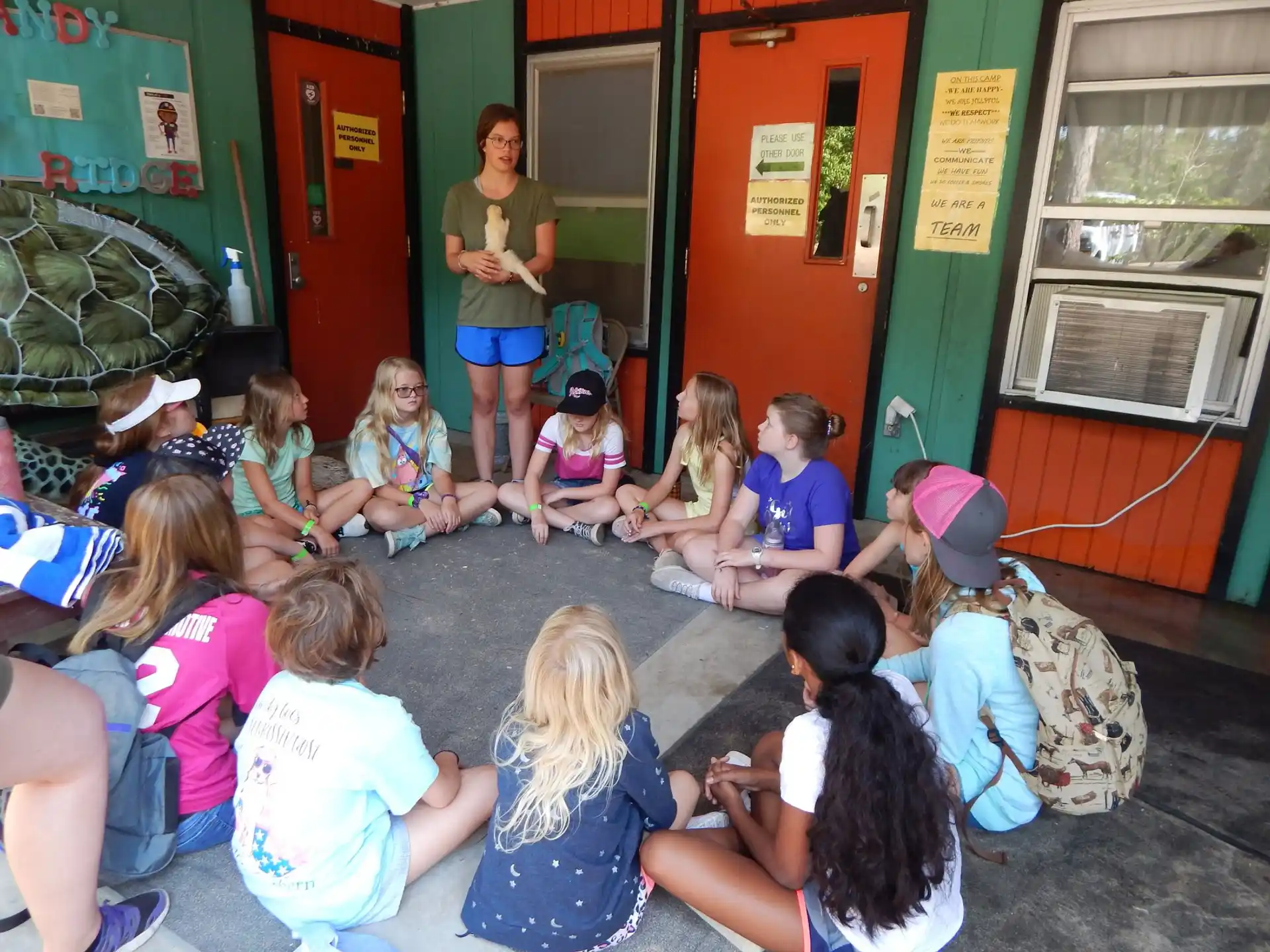 a group of children sitting on the floor in front of a person