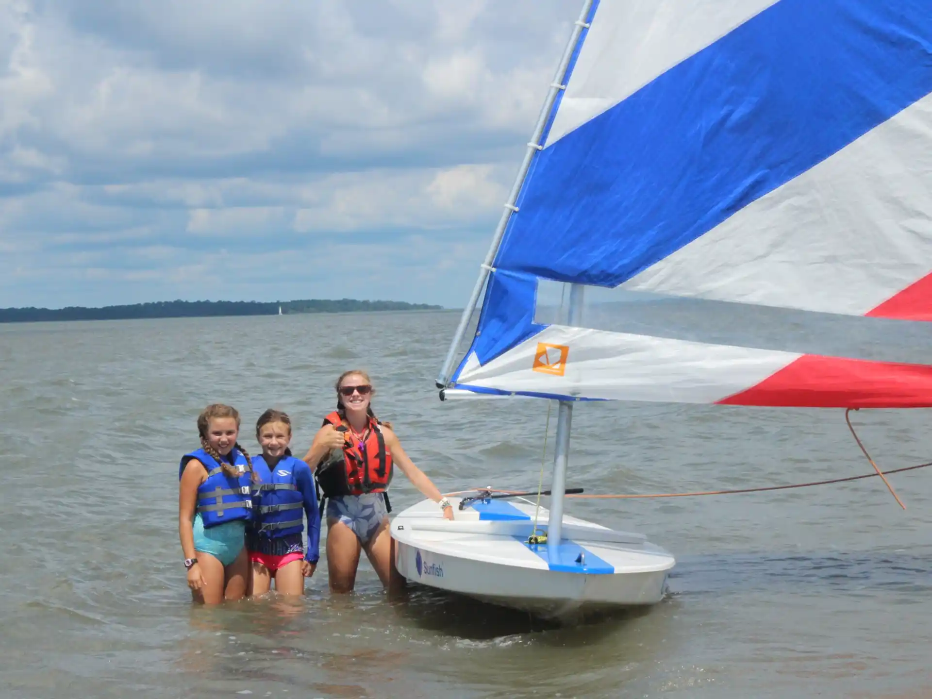 a group of people on a sailboat in the water