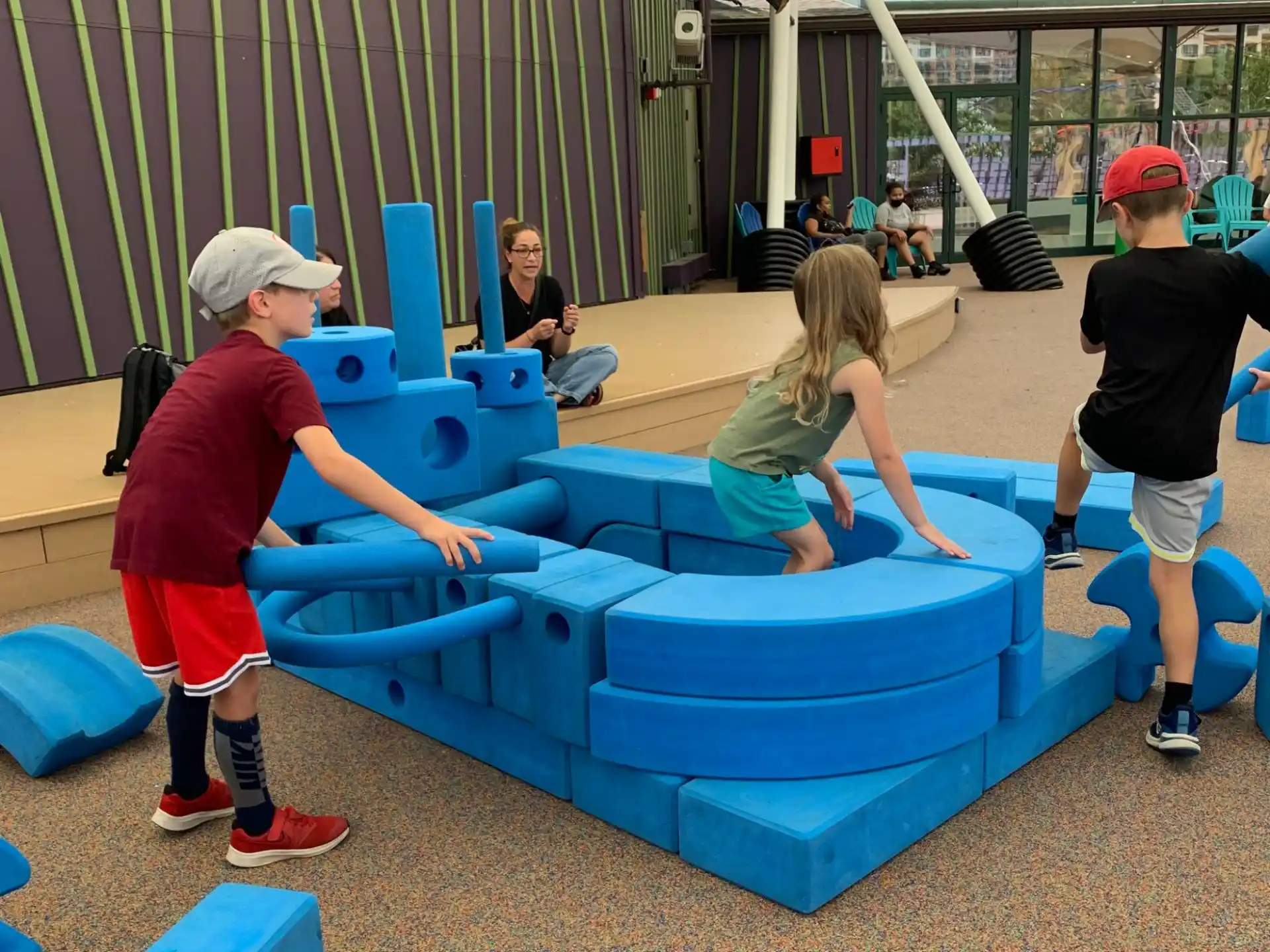 a group of people playing on a blue trampoline