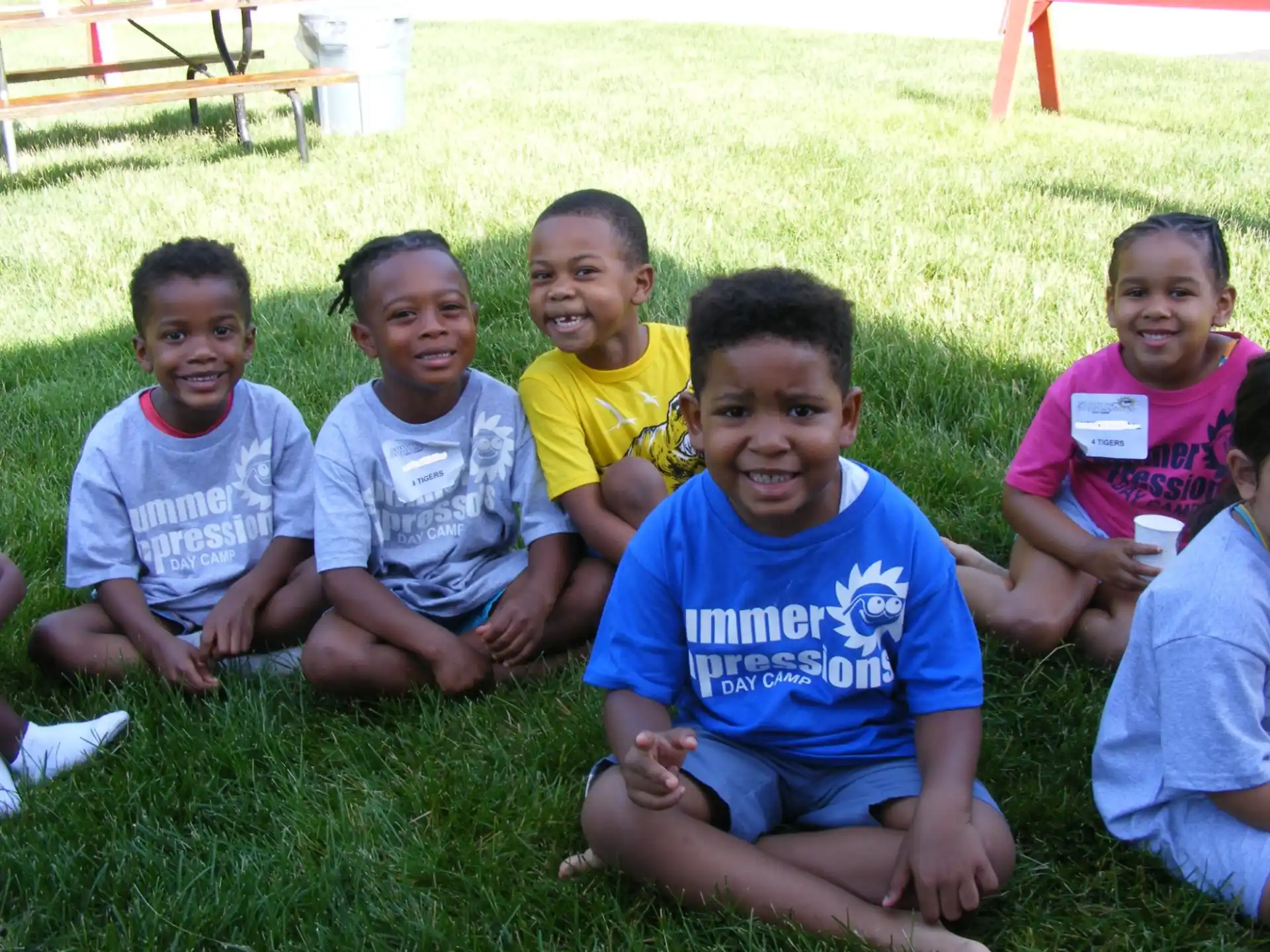 a group of children sitting on the grass