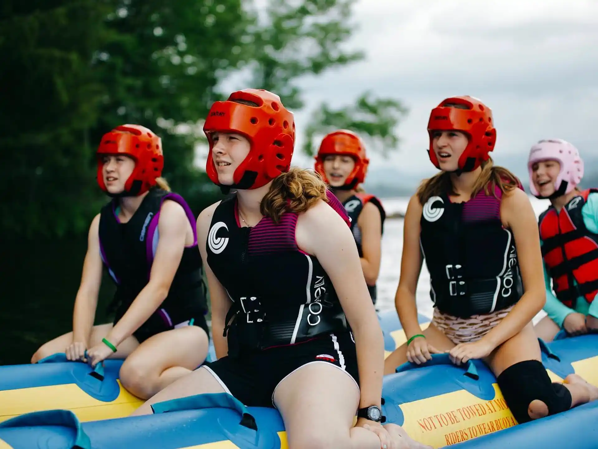 a group of people wearing helmets and riding a raft