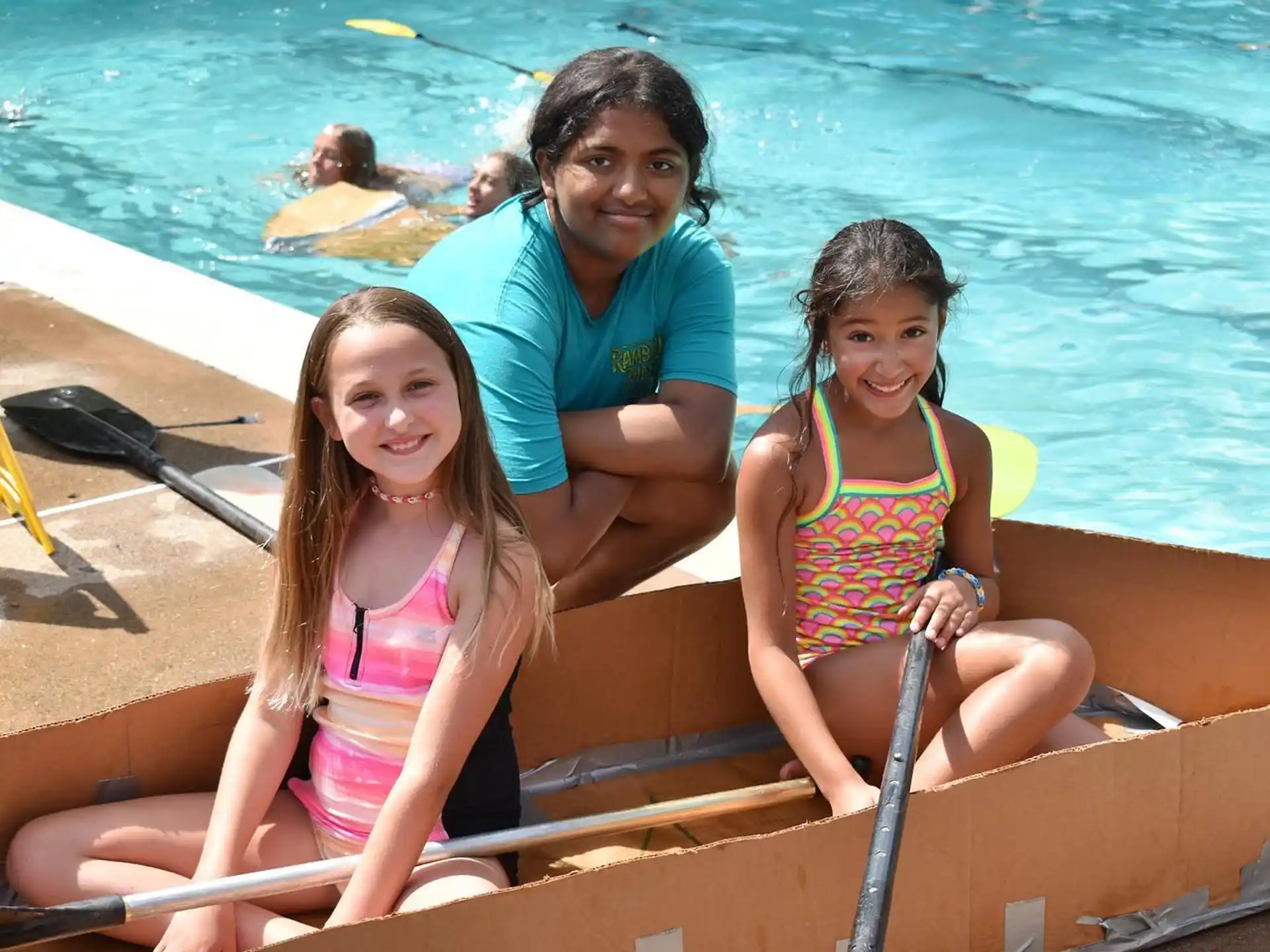 a group of people posing for a photo by a pool