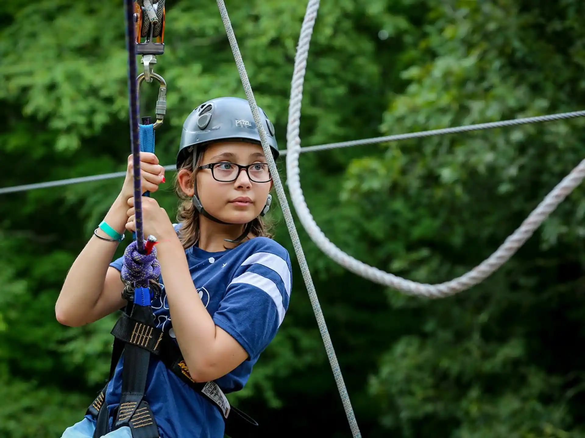 a girl in a harness holding a bow and arrow