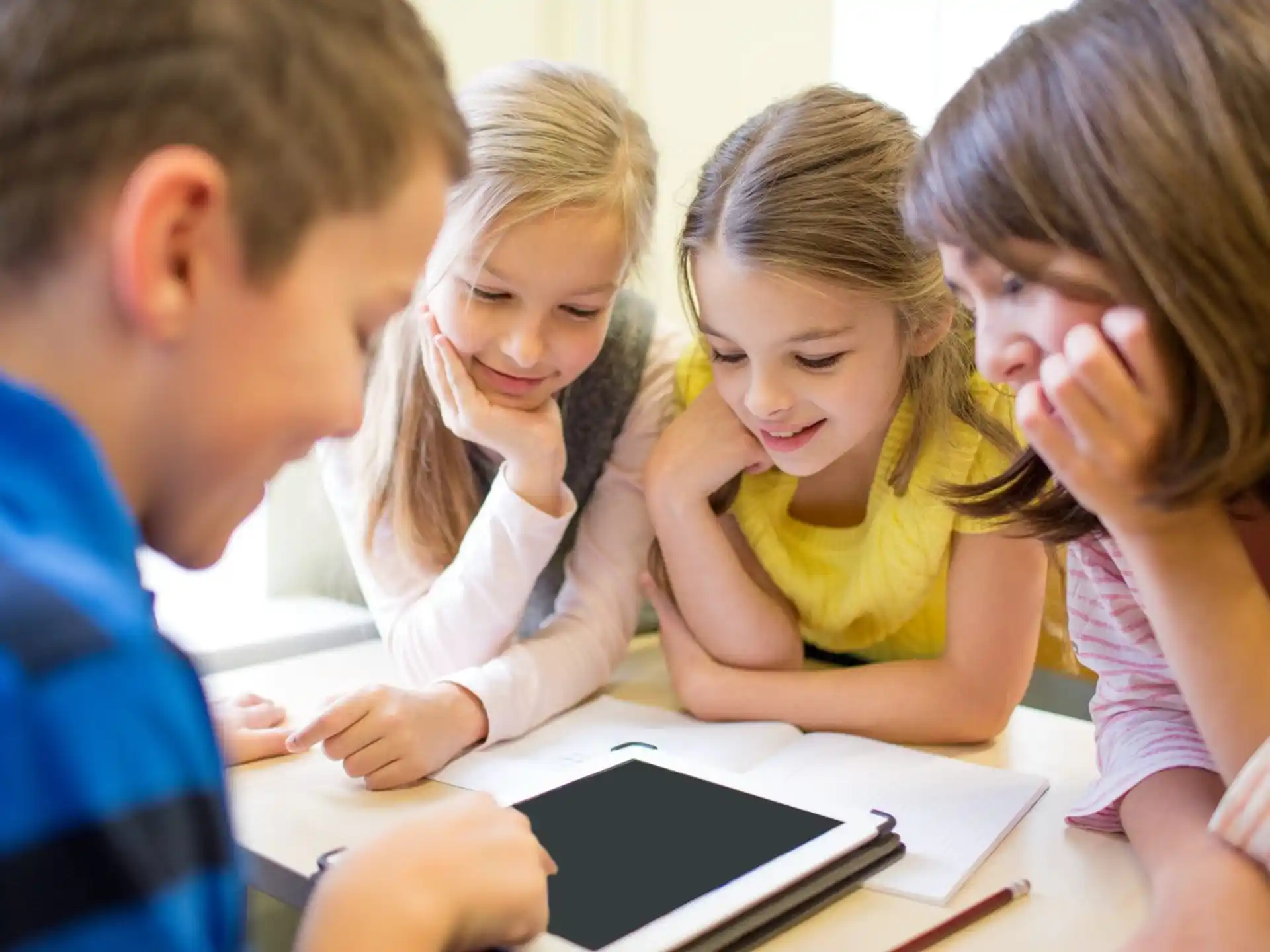 a group of children looking at a tablet