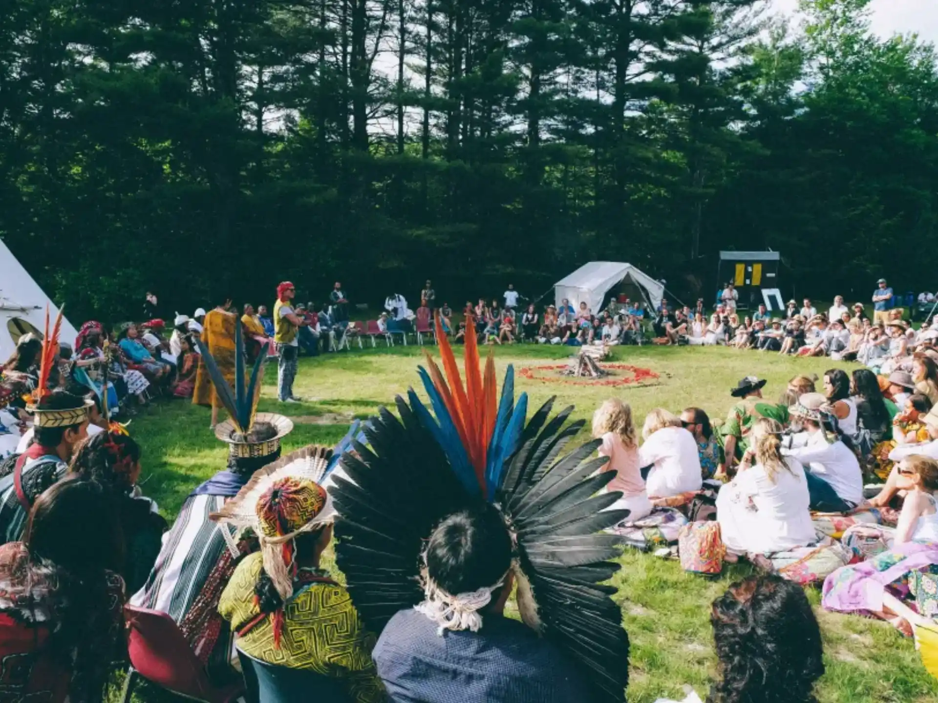a group of people sitting on the ground with a crowd watching