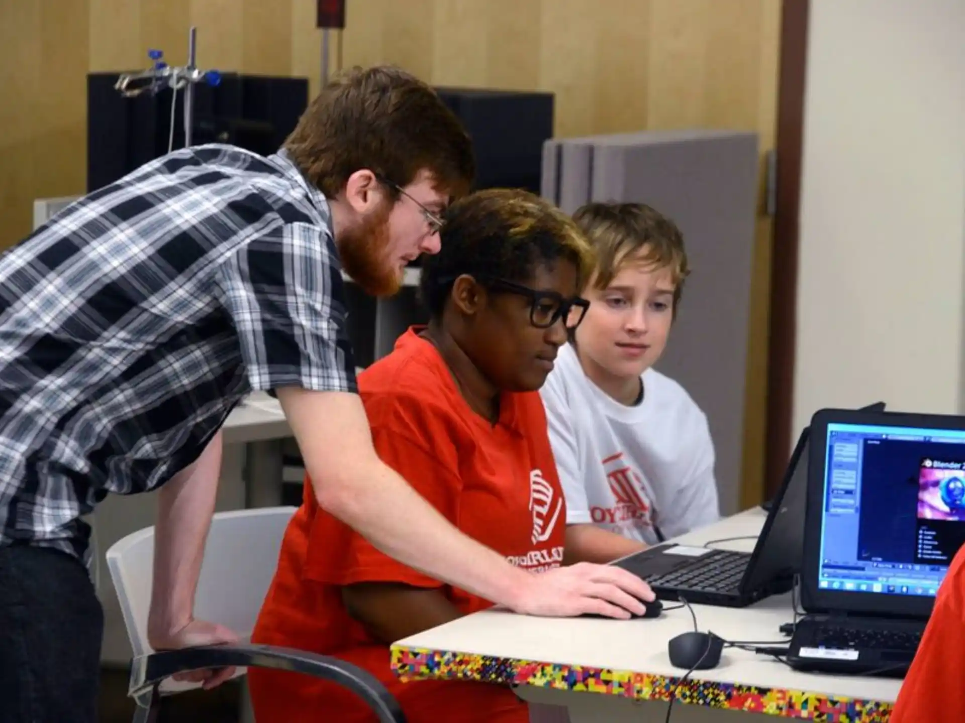 a group of people looking at a laptop