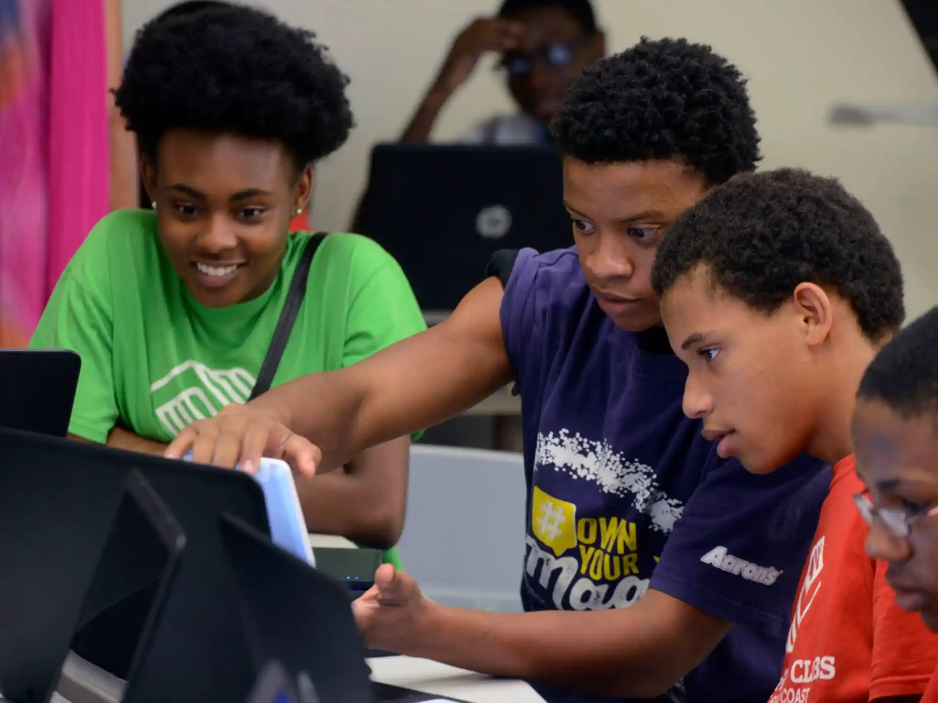 a group of young boys looking at a laptop