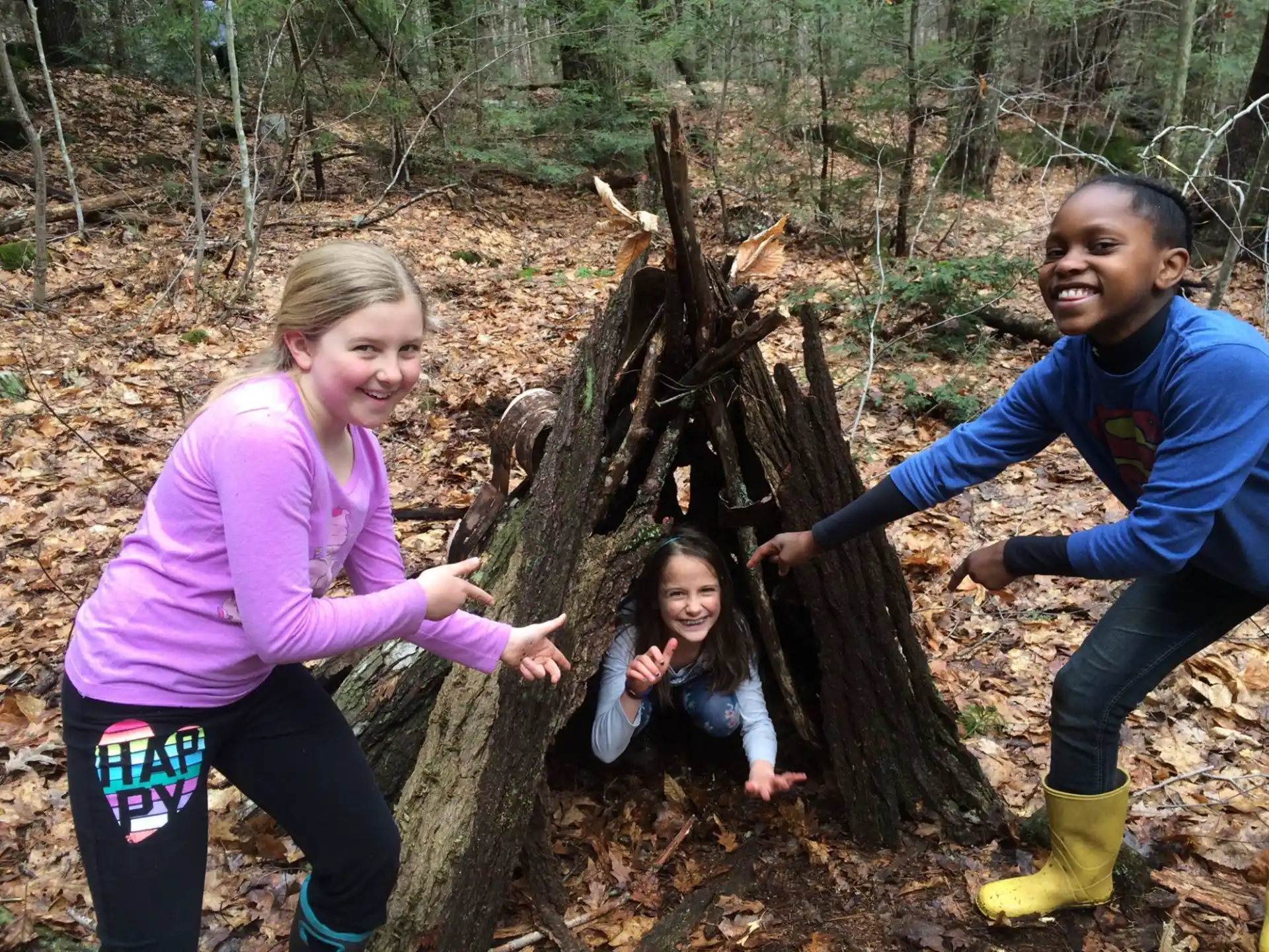 a group of people posing for a picture next to a tree stump