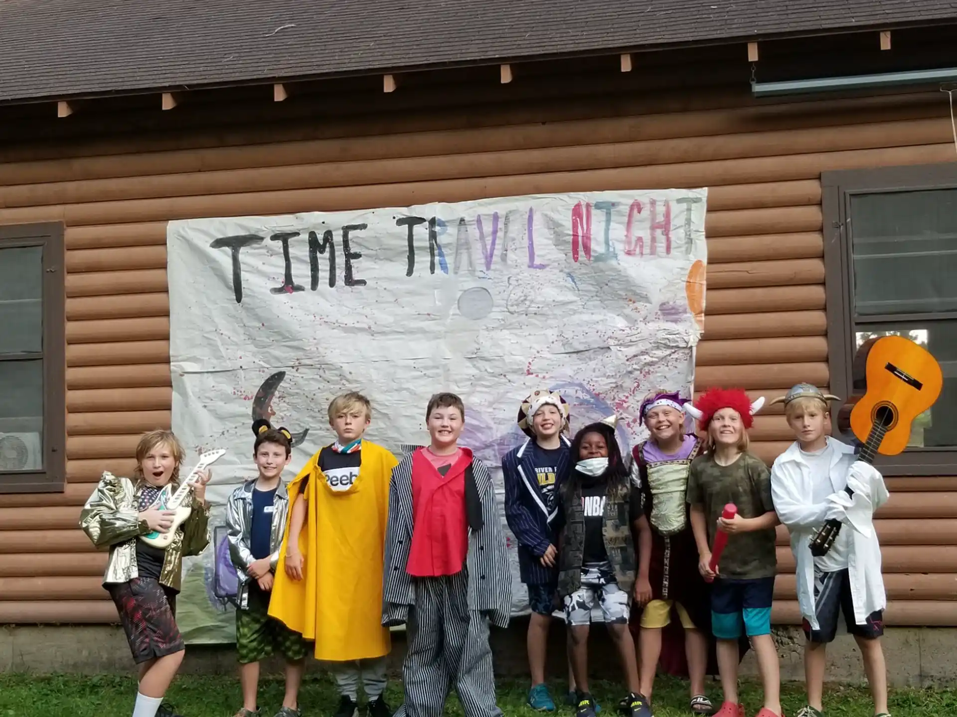a group of children posing for a photo in front of a house