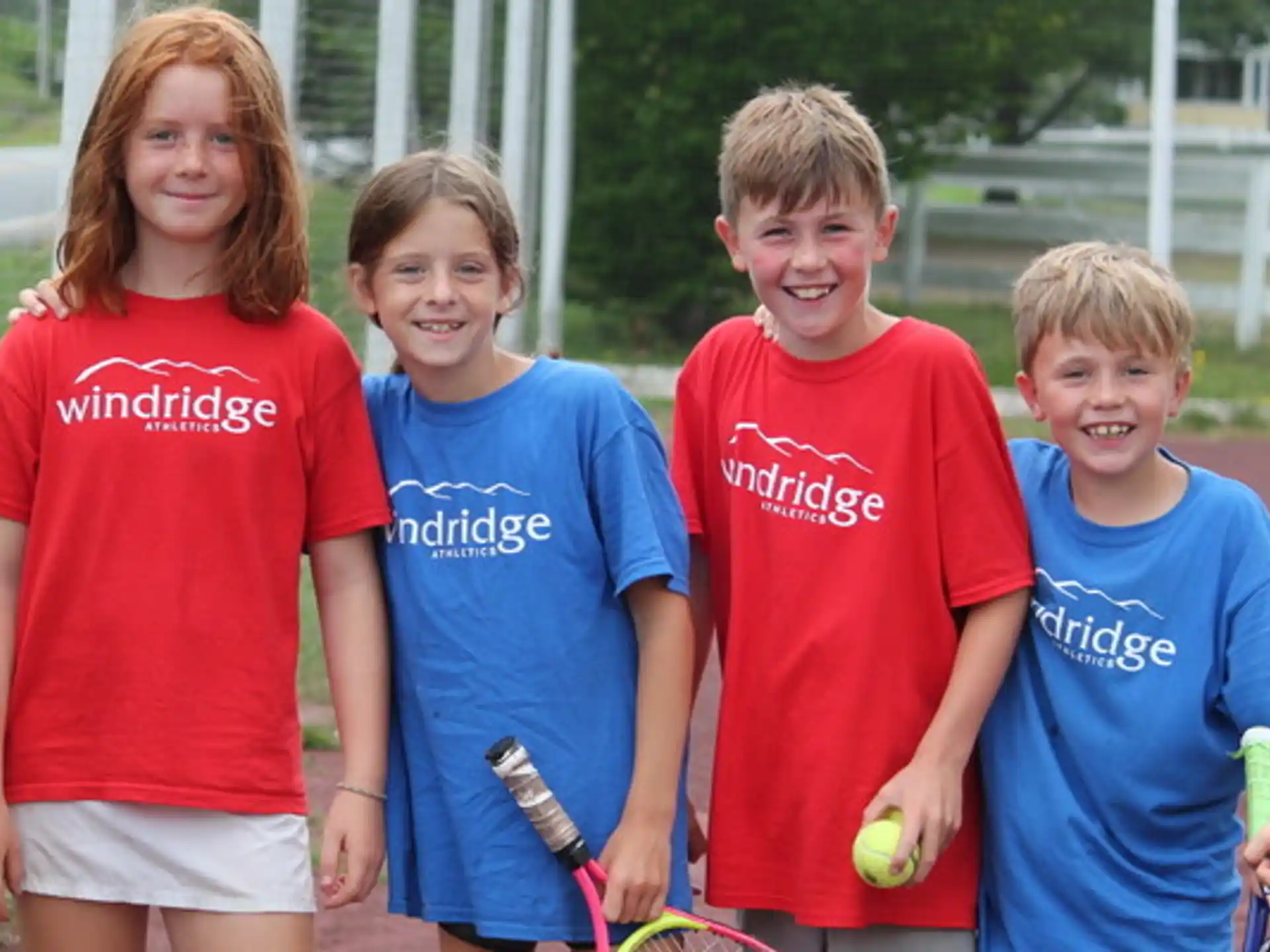 a group of kids pose for a picture with tennis rackets