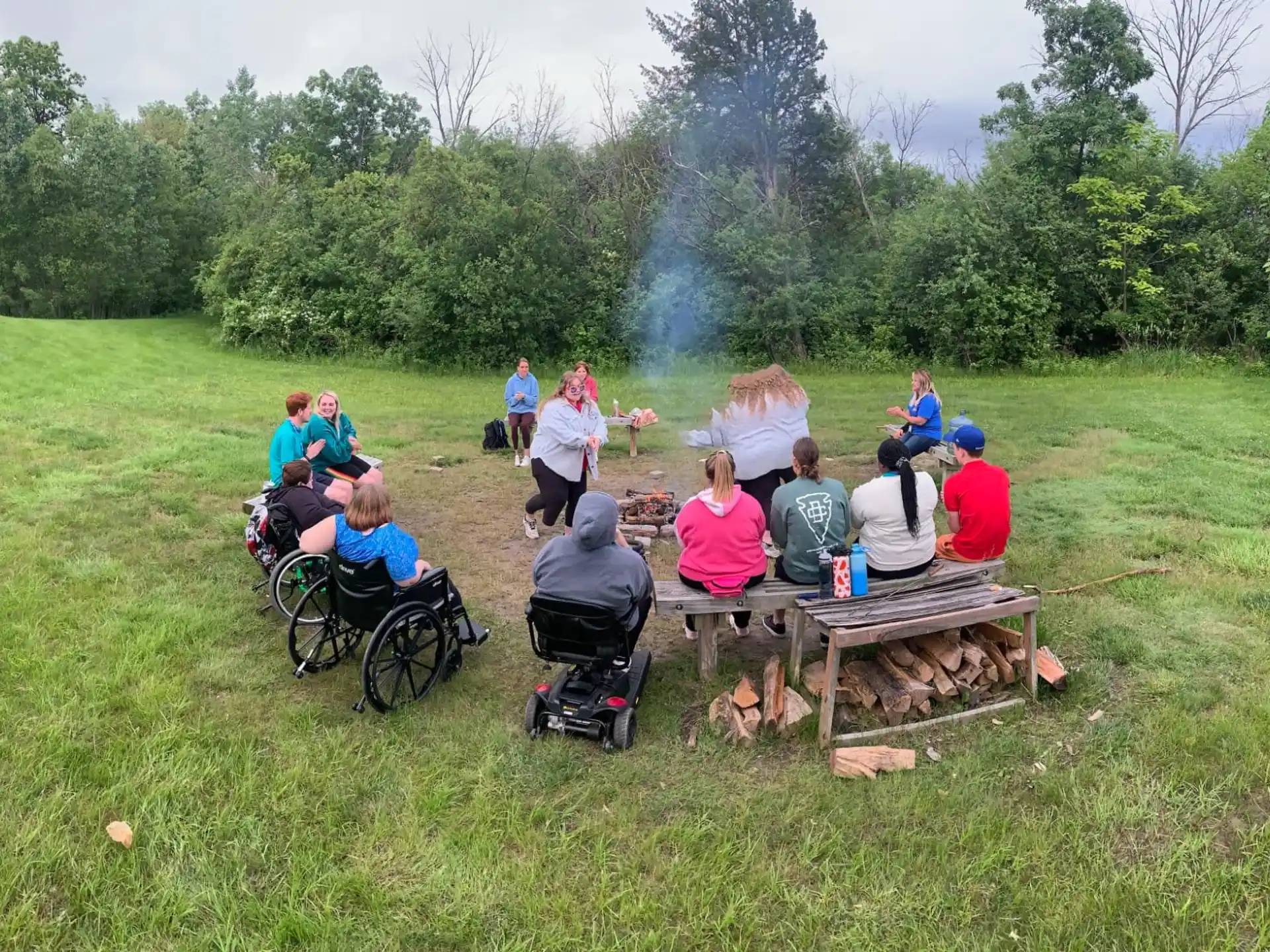 a group of people sitting at picnic tables in a field