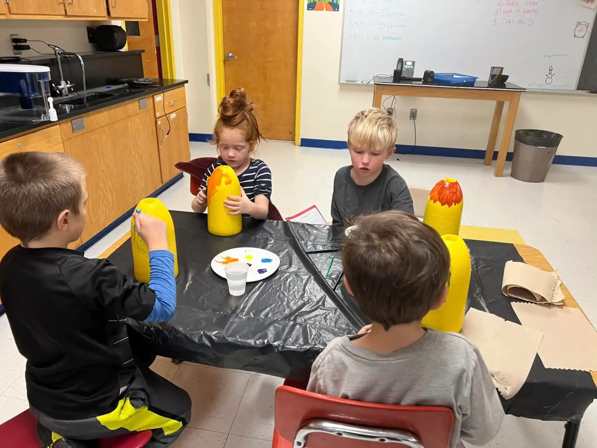 a group of children sitting around a table
